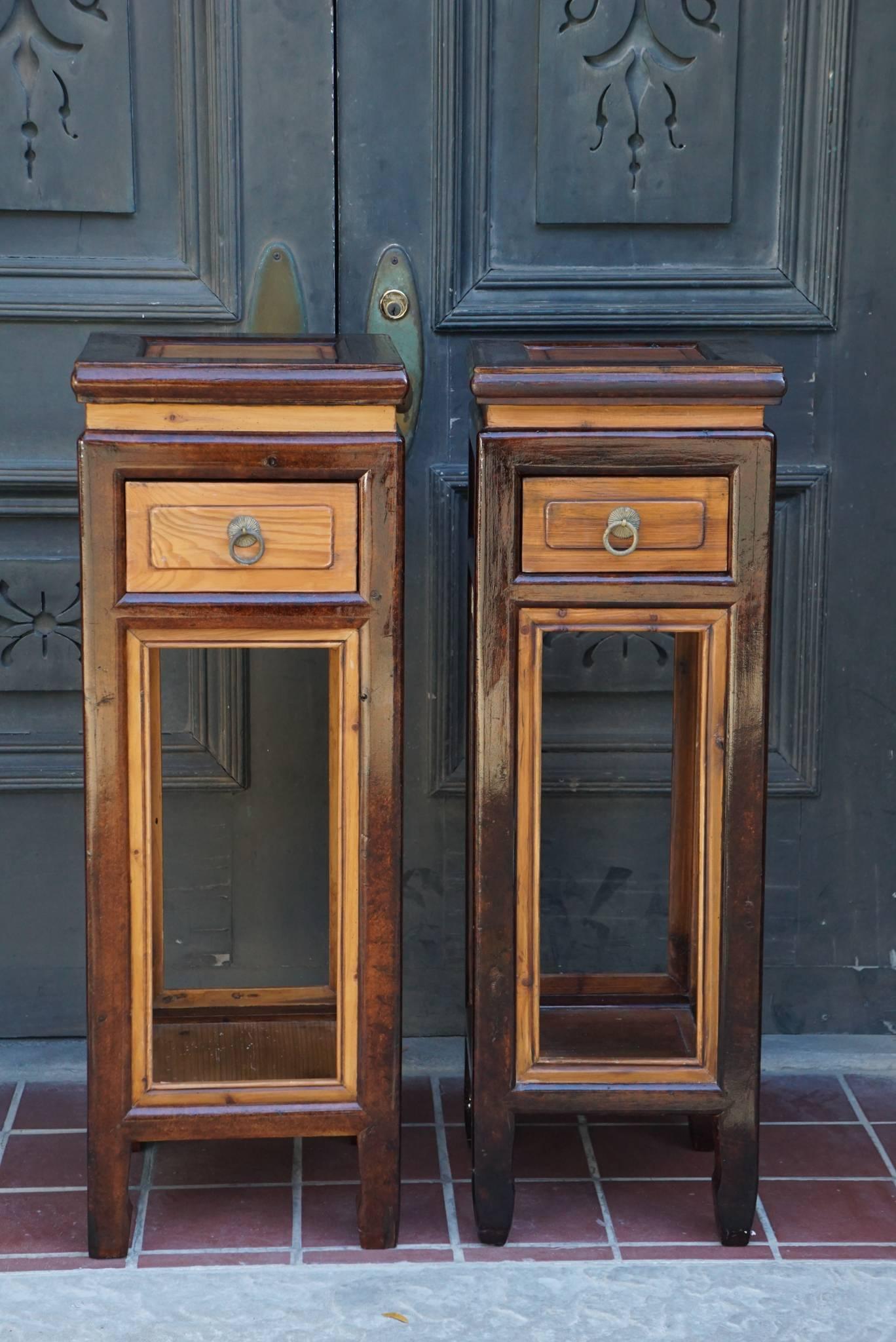 This pair of Chinese provincial elm stands, circa 1890-1900. Probably at one time completely covered in lacquer the wood has been exposed in areas creating an interesting contrast of surfaces. They are made with a single drawer and can be used as