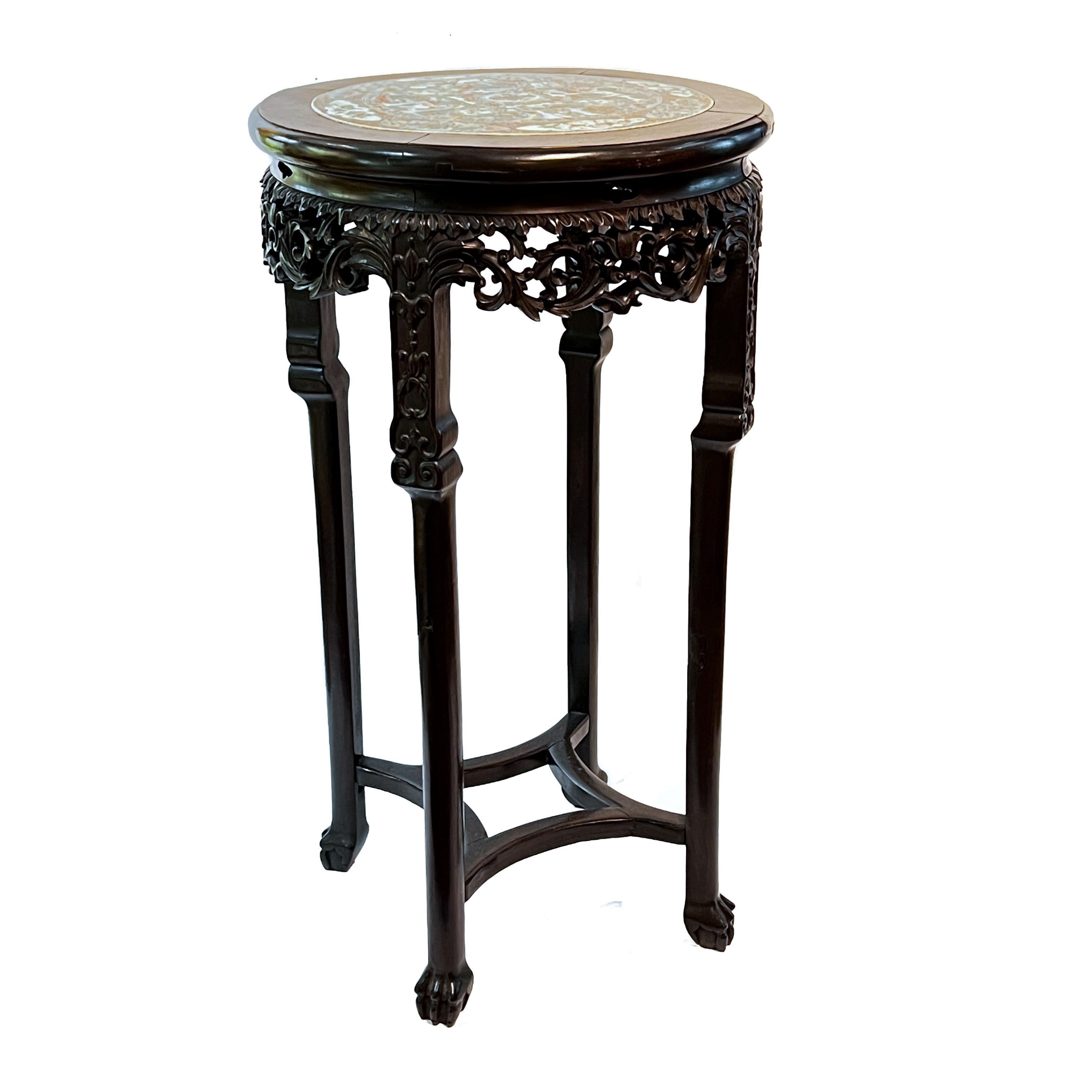 Our exceptional pair of Qing period Chinese plant stands are carved from rosewood and feature porcelain tops in the famille verte style. Each in good condition, with scratches and rubbing wear, and two legs with gouges.