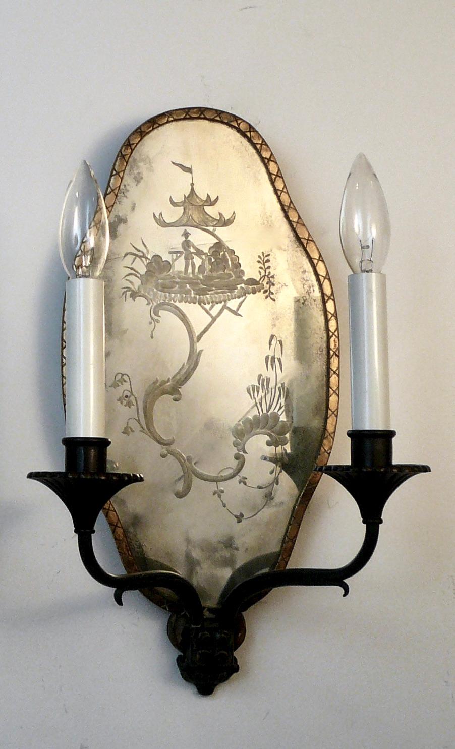 This handsome pair of Old English style two light sconces feature wheel cut cartouche form mirrored backs of chinoiserie design.
These sconces were originally installed in the dining room at Ben Elm, the turn of the Century Pittsburgh home of
