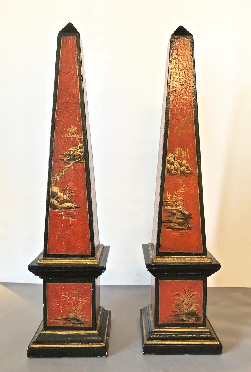This is a large pair of 20th century painted lacquer Obelisks in a traditional cinnabar color with black and gold chinoiserie decorations. The obelisks are in overall good condition, with a few minor touch up to the painted surfaces. Obelisks of