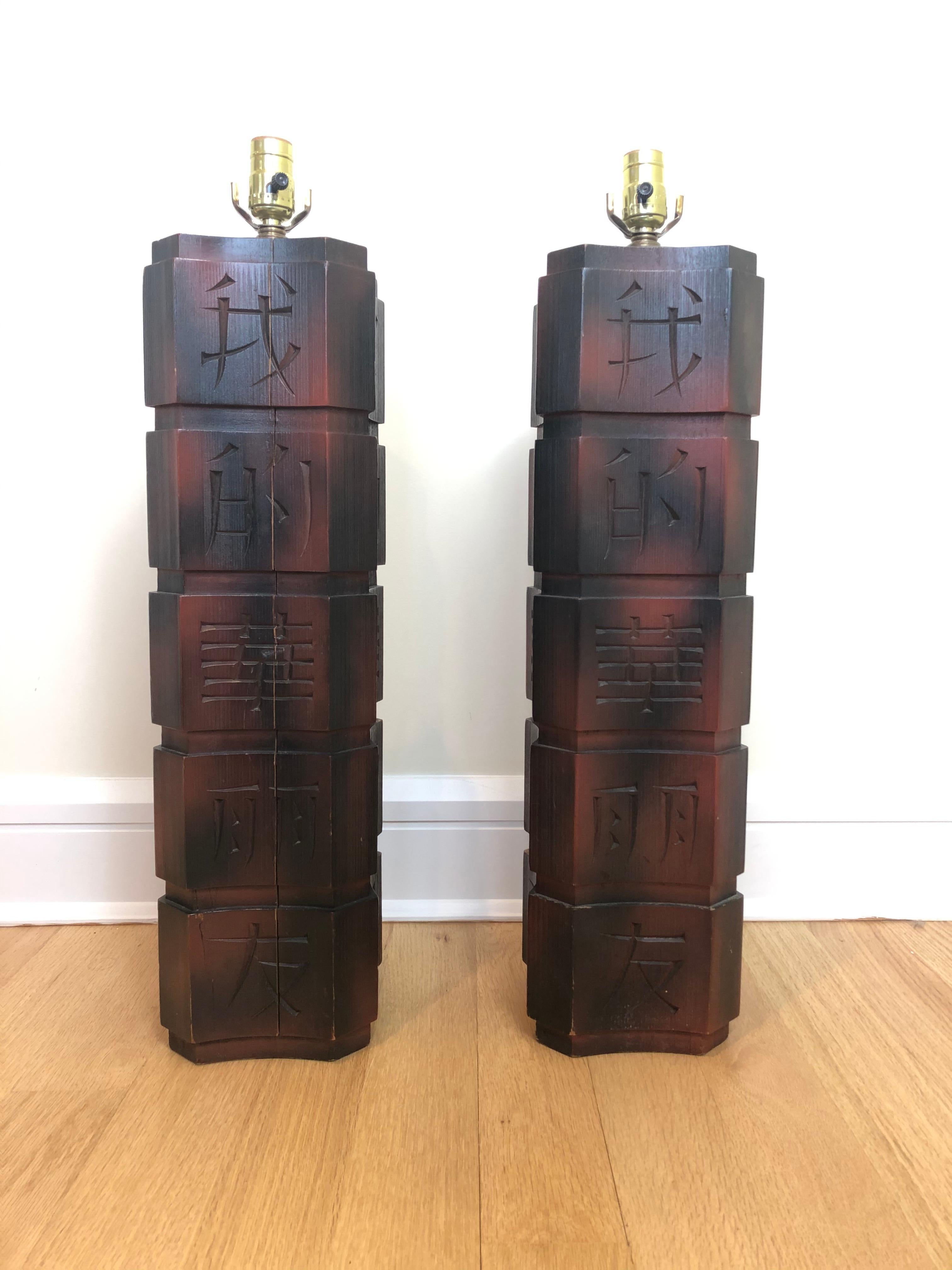 Pair of James Mont calligraphy decorated carved wood table lamps. All original James Mont table lamps with carved Chinese calligraphy characters on all sides of tall column forms. Original finish.