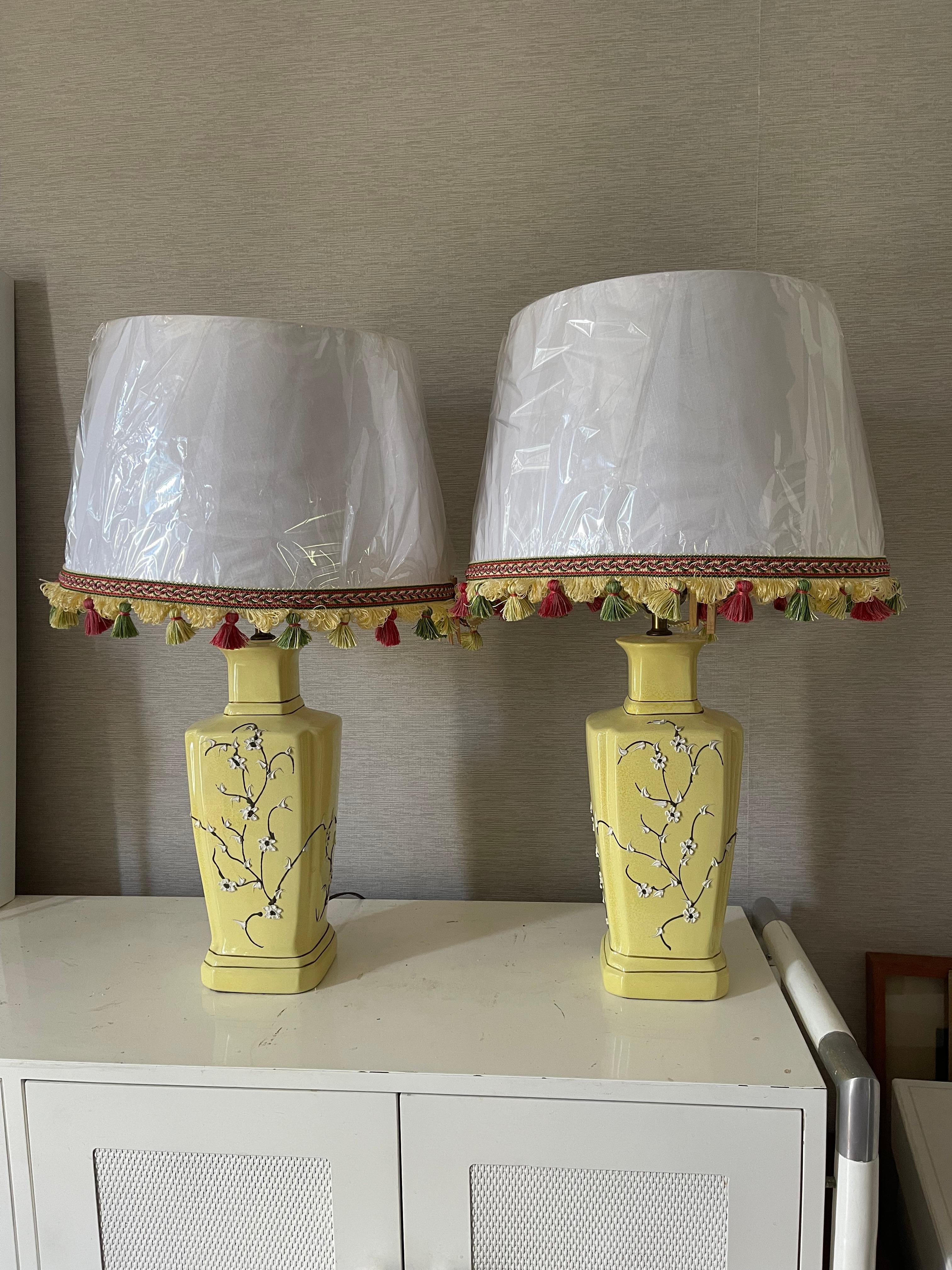 Light yellow with white blossoms ceramic chinoiserie pair of Lamos with fringed shades with tassels. Also available shades option with multicolored rope.