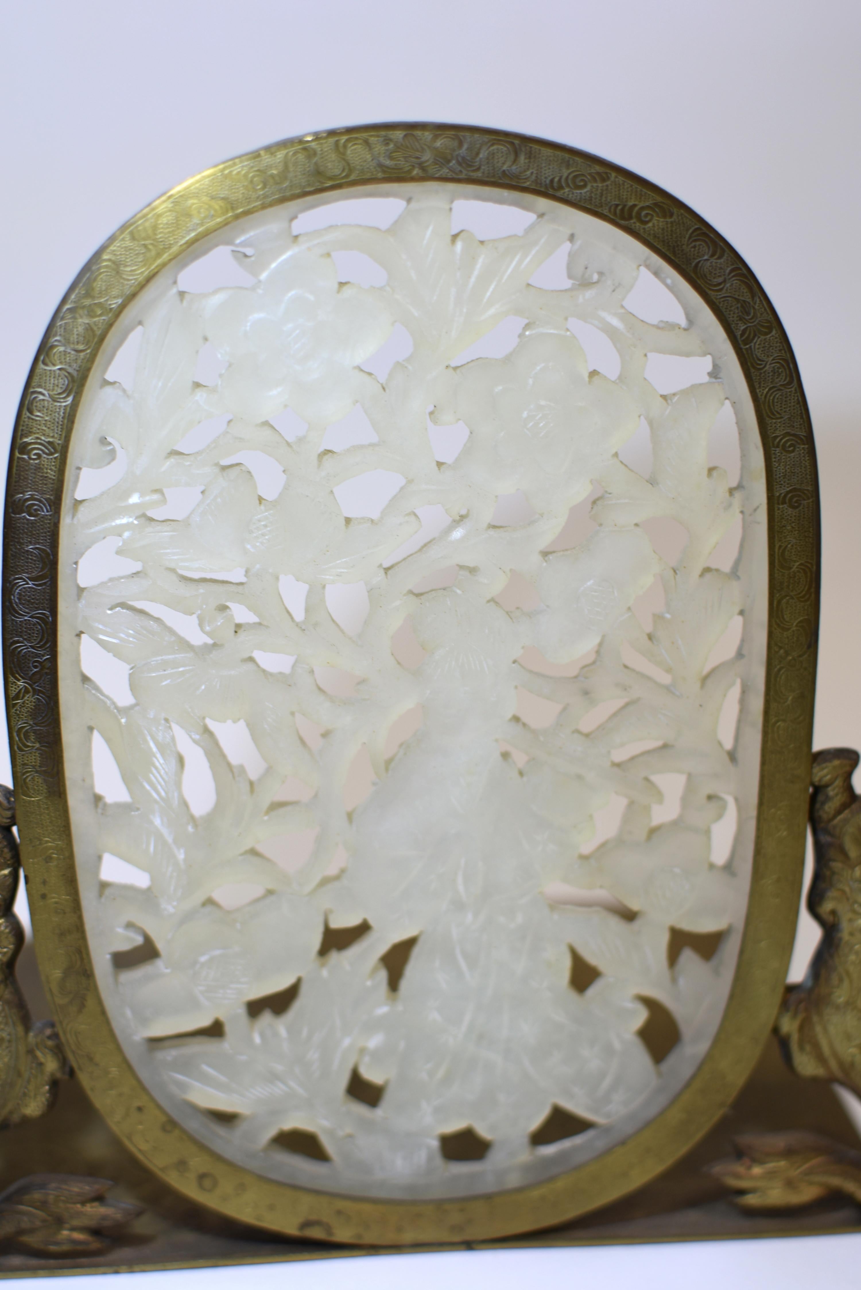 An exceptional pair of Chinese antique jade solid brass bookends. Large, oval insets of white jade, exhibiting a beautiful translucent clarity, form the centerpiece of each bookend. These hand-carved plaques depict immortals amidst a profusion of