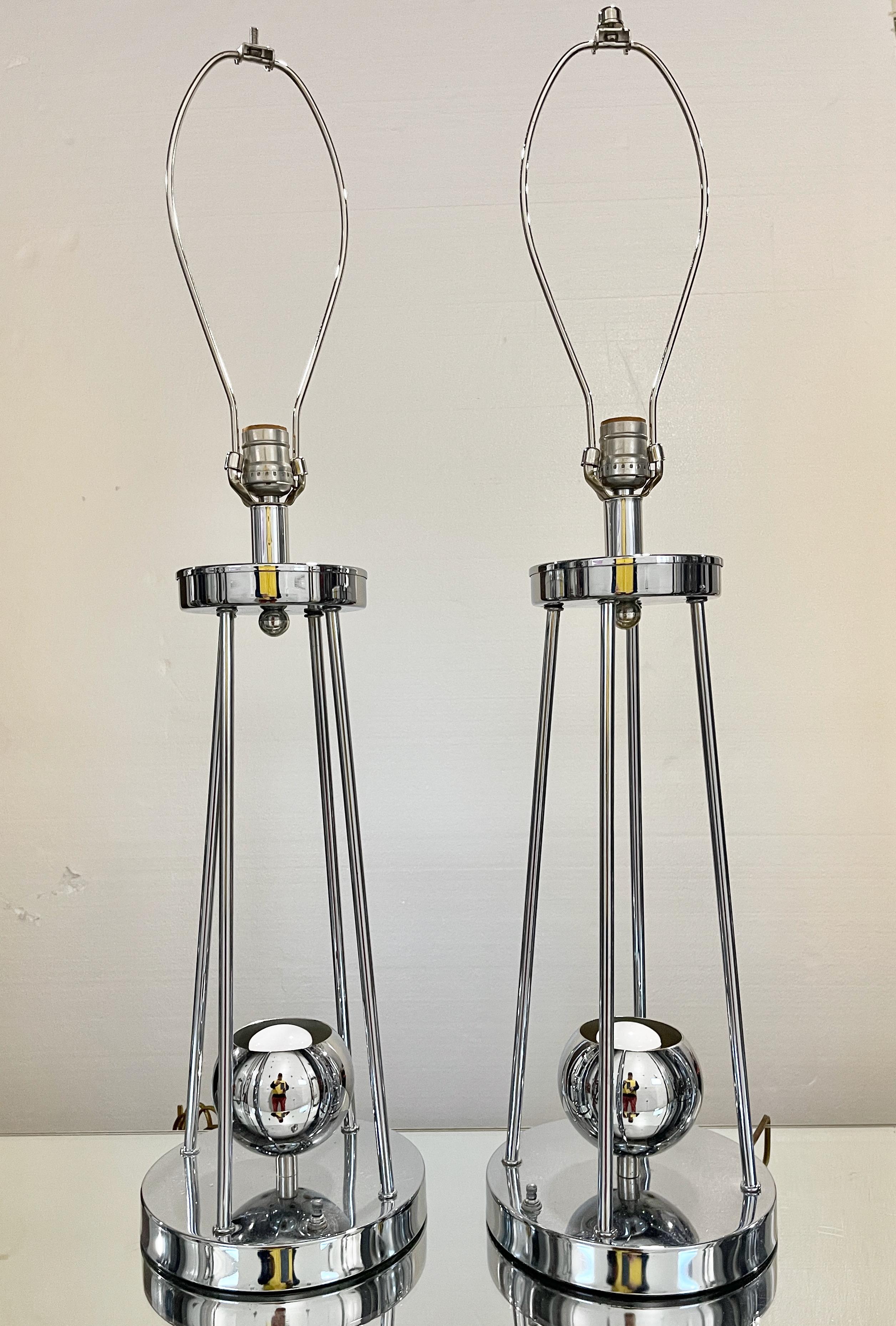 Pair of 1970's space age atomic chrome table lamps with both a upper standard edison screw lightbulb and a lower chrome eyeball in which you can use either a small spot/flood light bulb or a chrome top lightbulb. Switch on base allows independent