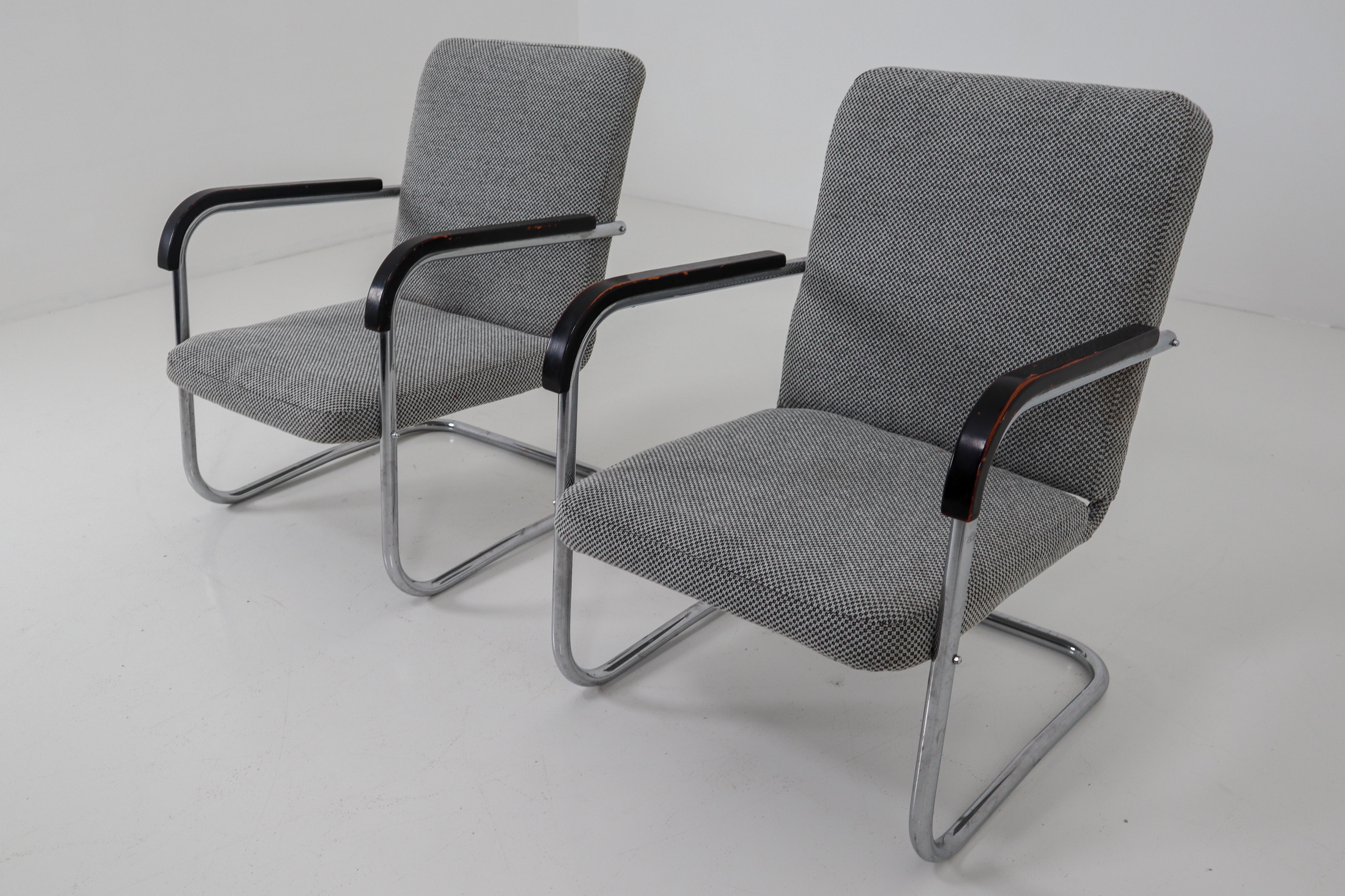 Pair of armchairs by Thonet circa 1930s midcentury Bauhaus period. These cantilever armchairs are typical for the German and Eastern Europe Bauhaus era. These armchairs has a tubular steel frame and is Re-upholstered with a grey fabric. The original