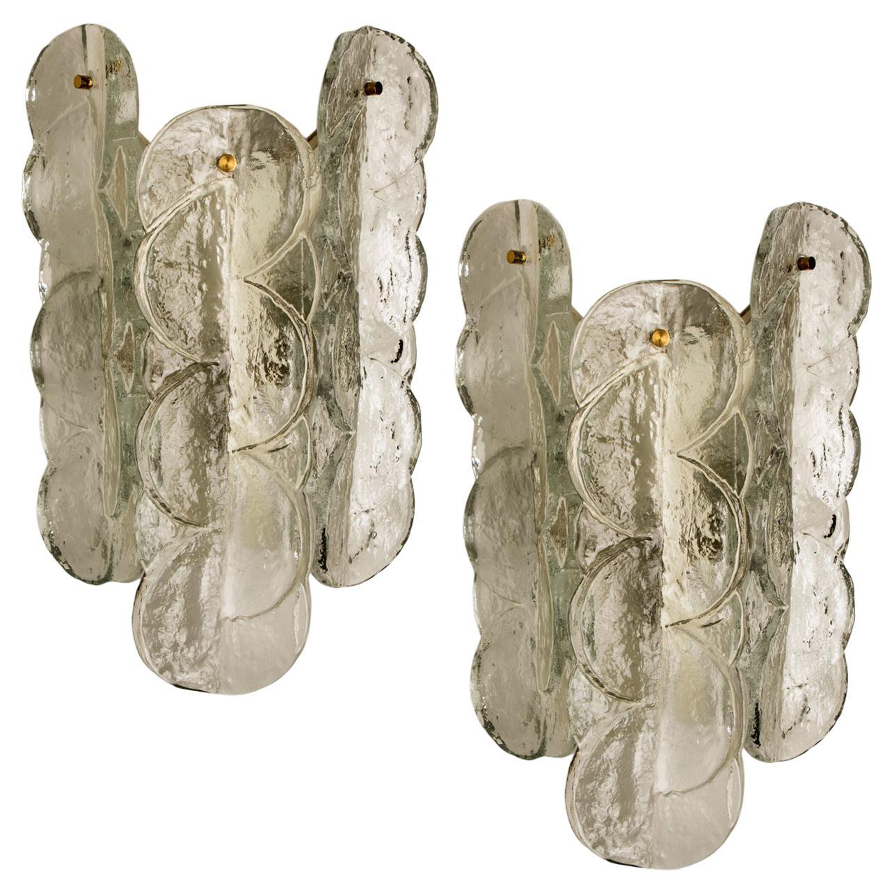 Pair of Kalmar swirl sconces wall lights with clear colored swirl glass. Beautiful, thick textured glass is complimented by brass and metal white metal hardware. Simple and clean design. Hand blown melting glass, made of clear glass. High quality