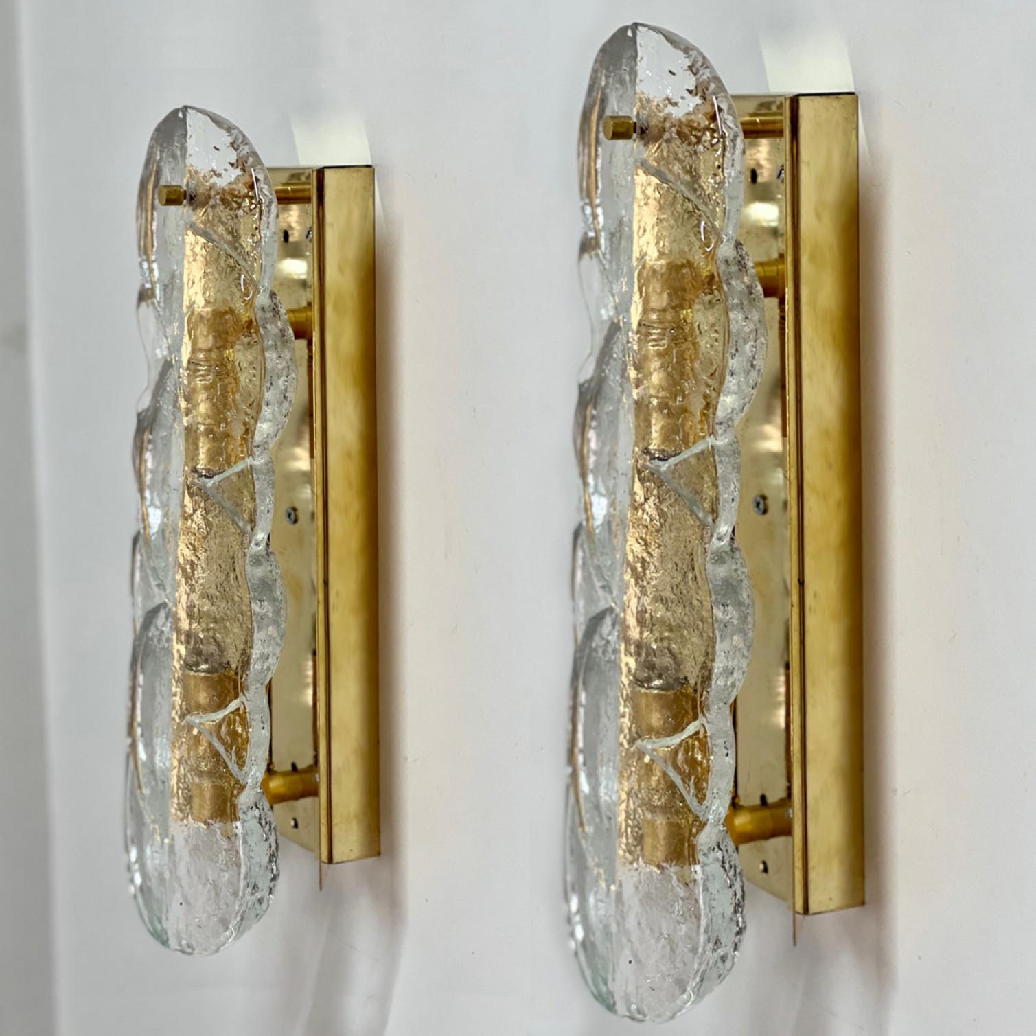 Kalmar swirl Wandleuchten mit klarem Glas in Zitrusform, entworfen und hergestellt in Österreich, Europa von J.T. Kalmar/Kalmar Lighting um 1969. Wunderschönes, dickes, strukturiertes Glas wird durch Messing- und Metallbeschläge vervollständigt.