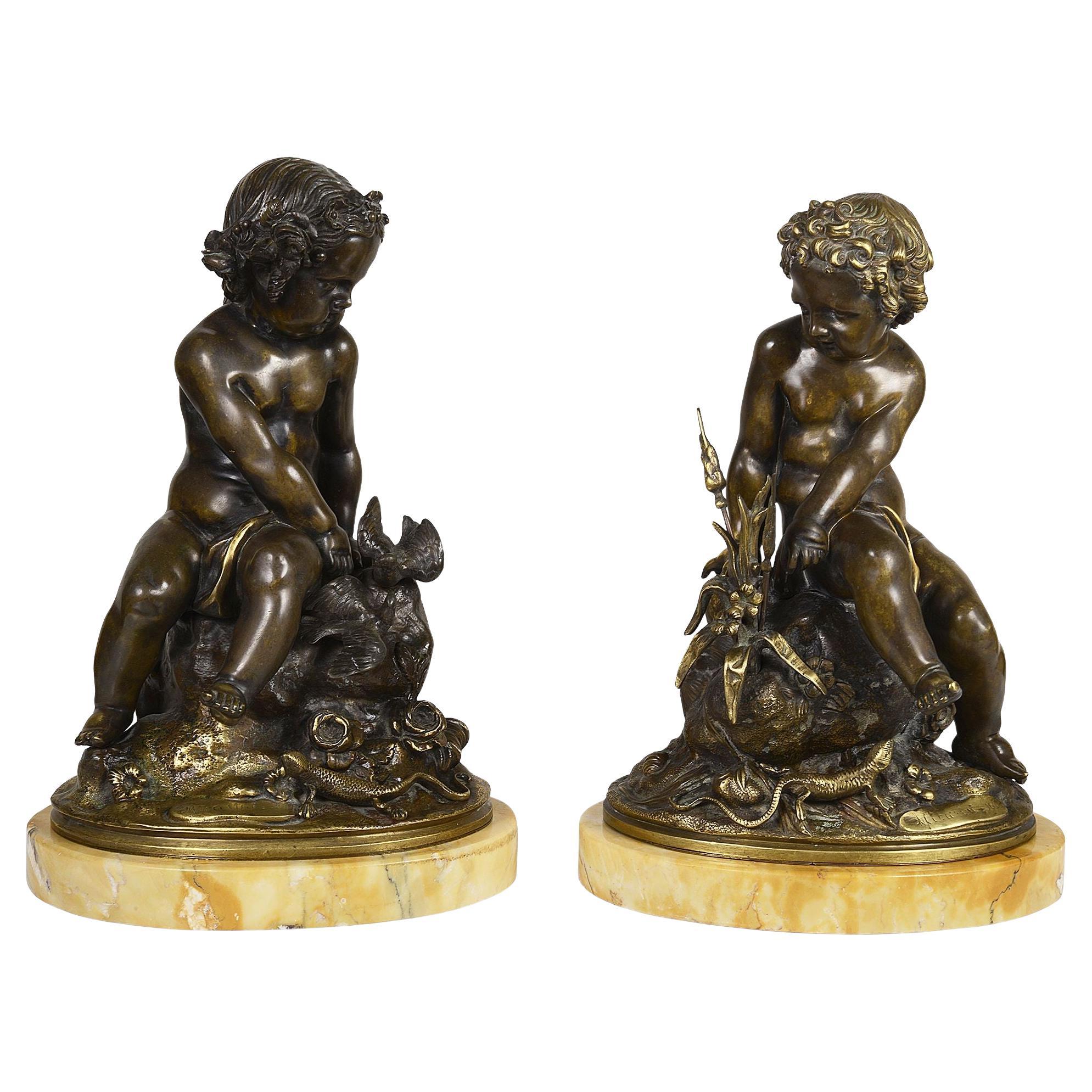 Coppia di putti classici in bronzo del XIX secolo seduti su una roccia