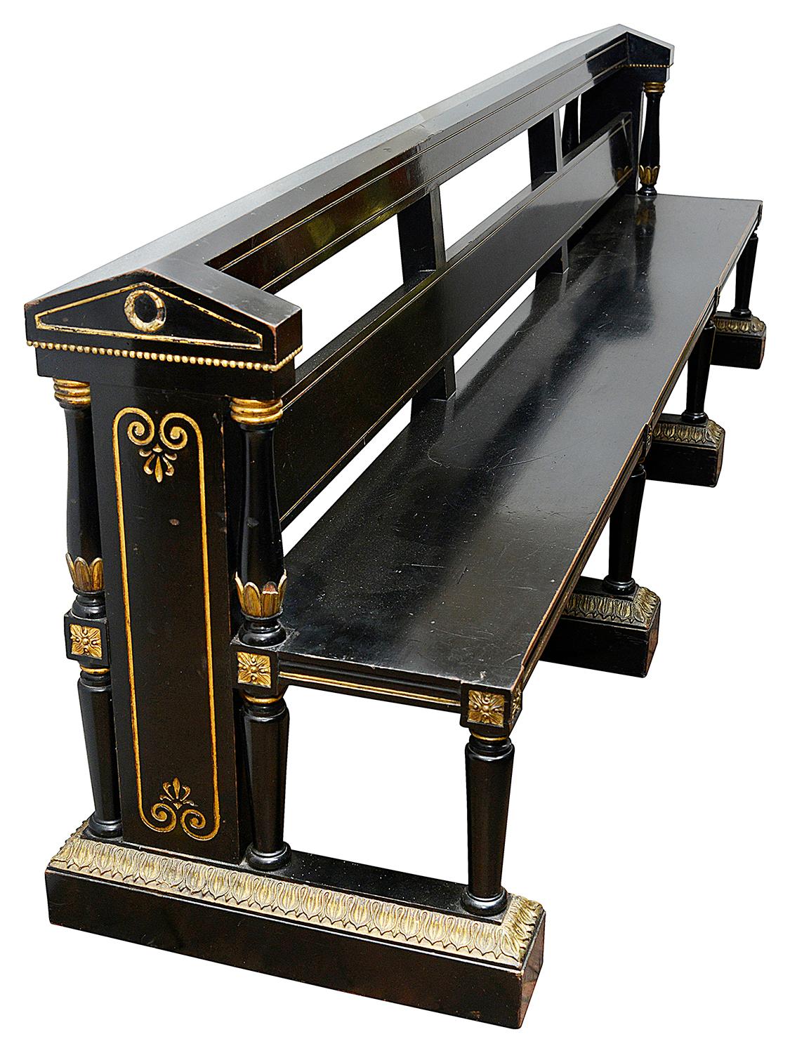 A very good quality pair of architectural 19th century Aesthetic movement ebonized hall benches, each with classical column and motif gilded decoration to the ends and raised on turned tapering supports and plinth bases.