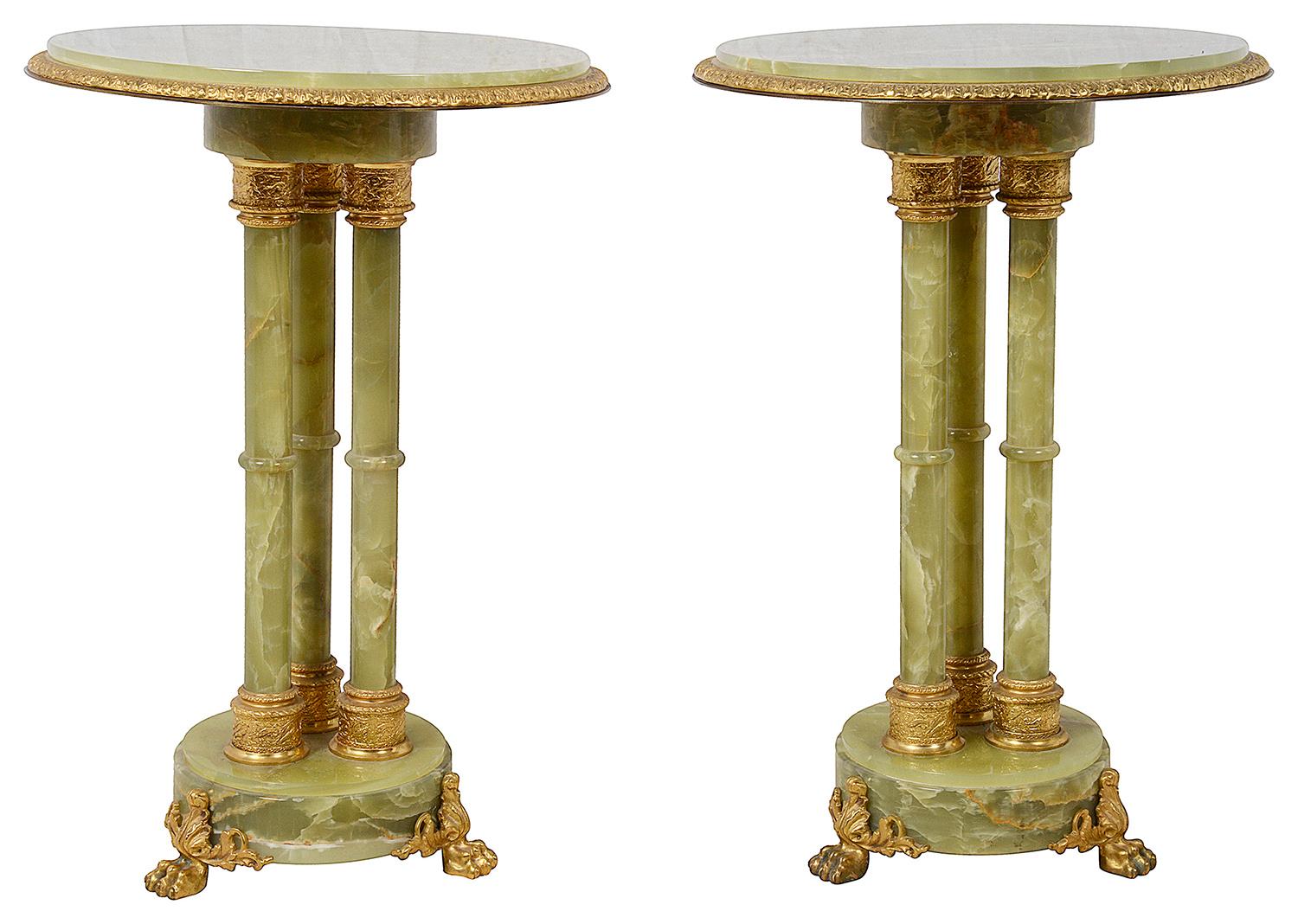 A good quality pair of classical circular Onyx side tables, each with three cluster column supports with gilded ormolu mounts, raised on circular plinth bases with ormolu claw feet. Circa 1920.