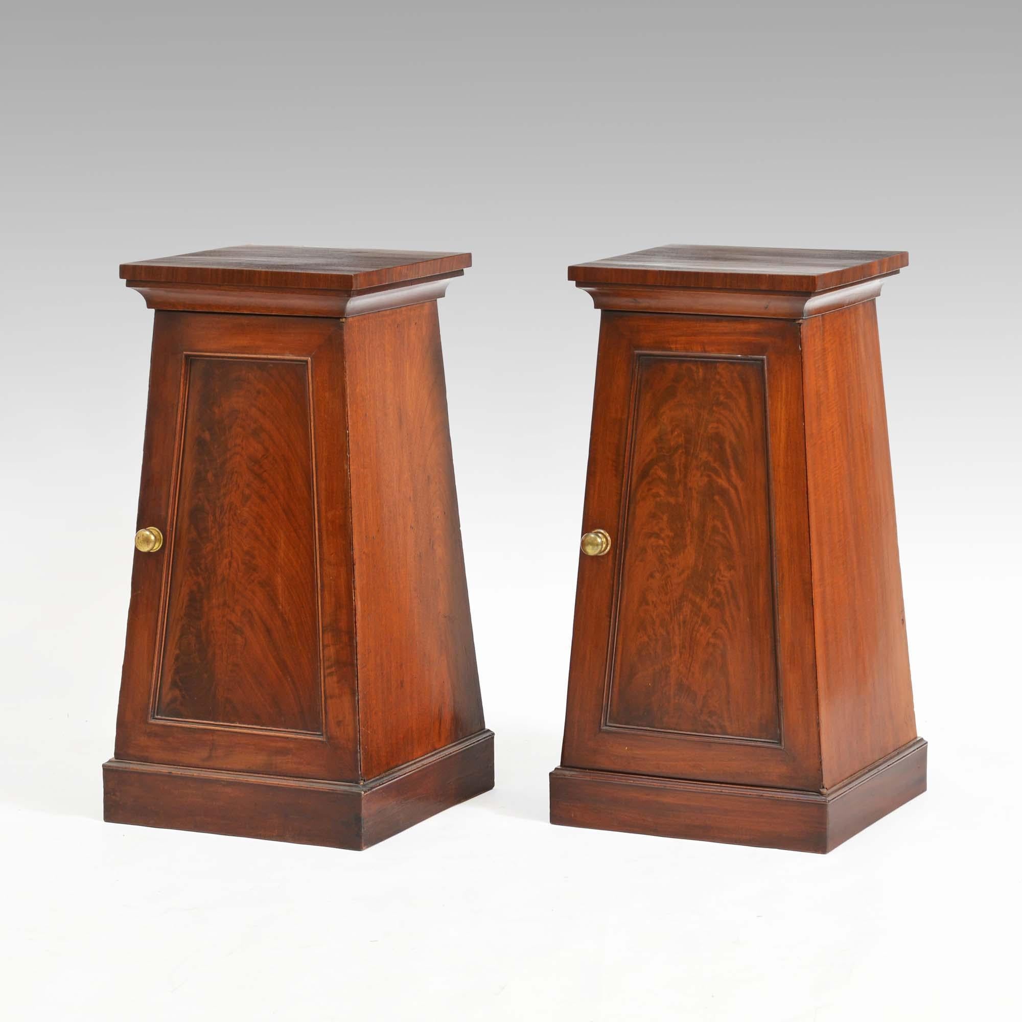 A pair of Regency tapered mahogany pedestal cabinets, the square cross-banded tops over caveto moulding, the doors with flame figured mahogany panels opening to interiors, each with a central shelf. Standing upon plinth bases
English, circa 1810 -