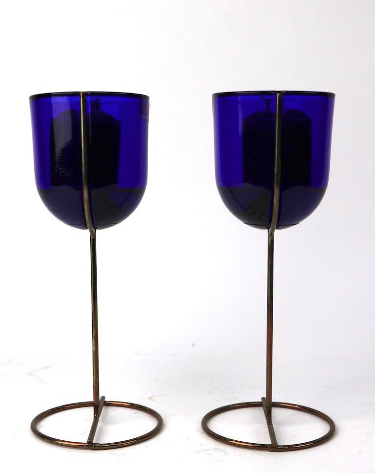 Interesting architectural design candlesticks by Ittala, Made in Finland, possibly designed by Kaj Franck. Cobalt glass cup inserts fit in metal stands, each retains original Ittala decal label. 3 inch diameter of base x 2.5 inch diameter of top.