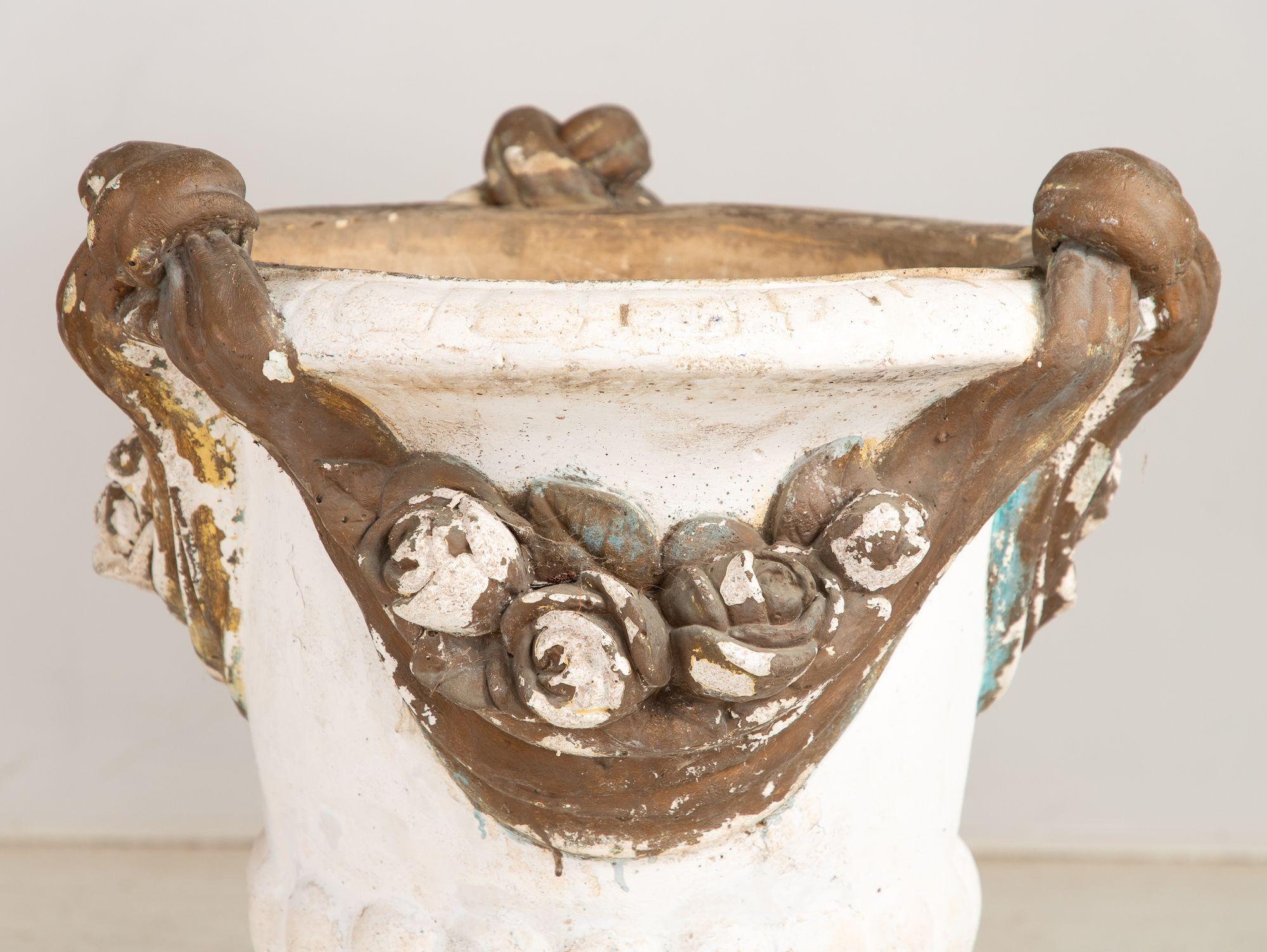 Un par de urnas de jardín italianas de mediados del siglo XX de estilo rococó, cada una de ellas de generosas dimensiones y que destilan elegancia clásica. Las urnas están pintadas de blanco, adornadas con tres detalladas guirnaldas con drapeados,