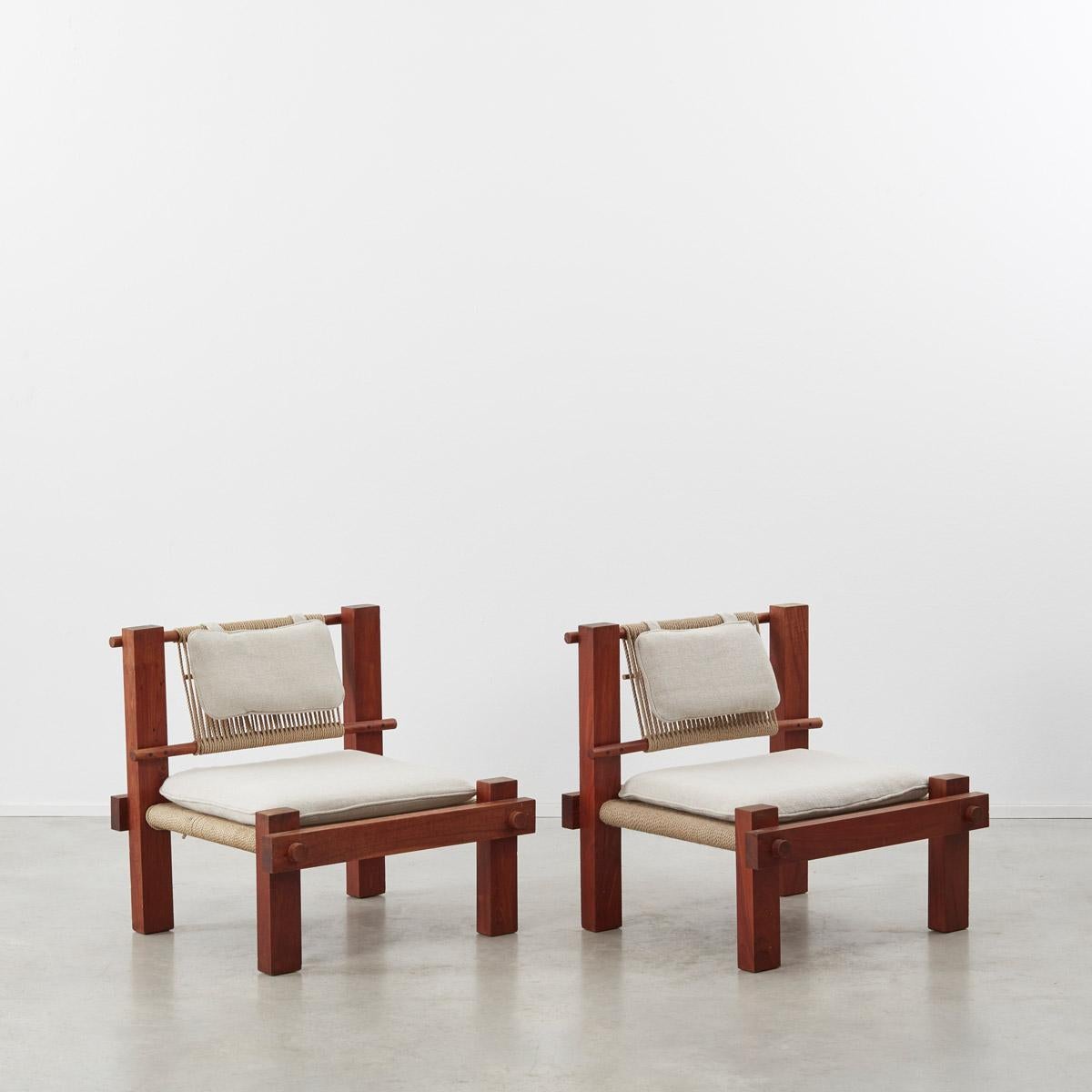 A pair of midcentury constructivist-style lounge chairs simply made from boxy hardwood frames and rope seats. While the thick bound cord is reminiscent of the 1952 rope chair by Jørgen Høj and Poul Kjærholm, Denmark, the boxy profile and stylized