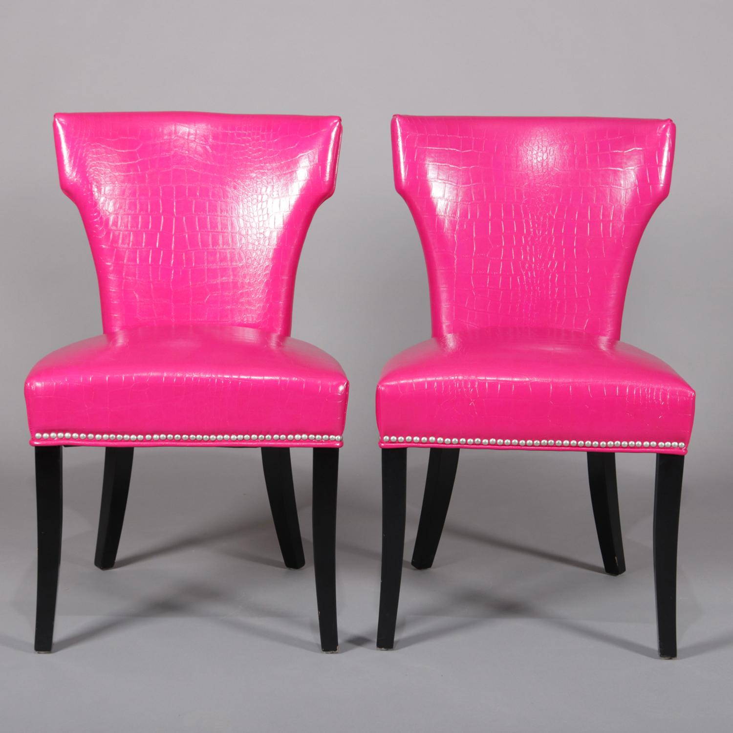 Pair of contemporary accent chairs feature fuschia pink alligator skin leatherette upholstery with shaped backs and raised on ebonized black legs, 20th century.

Measures: 37
