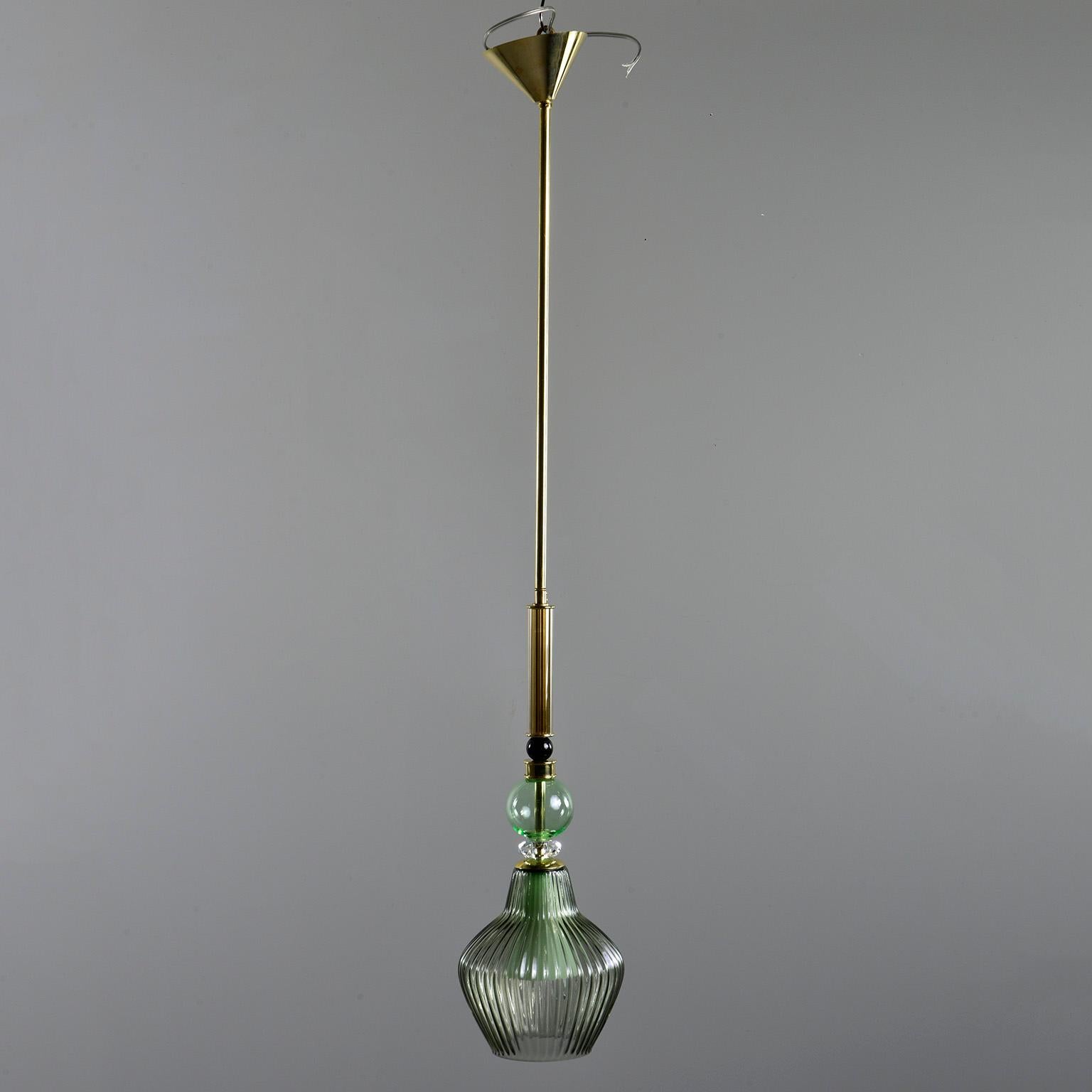 Pair of new green Murano glass and brass pendants feature cone-shaped polished brass canopies, 25” long center brass rods, ribbed green glass globes, clear faceted crystal accents, black glass beads and gold ribbed glass elements, circa 2018.