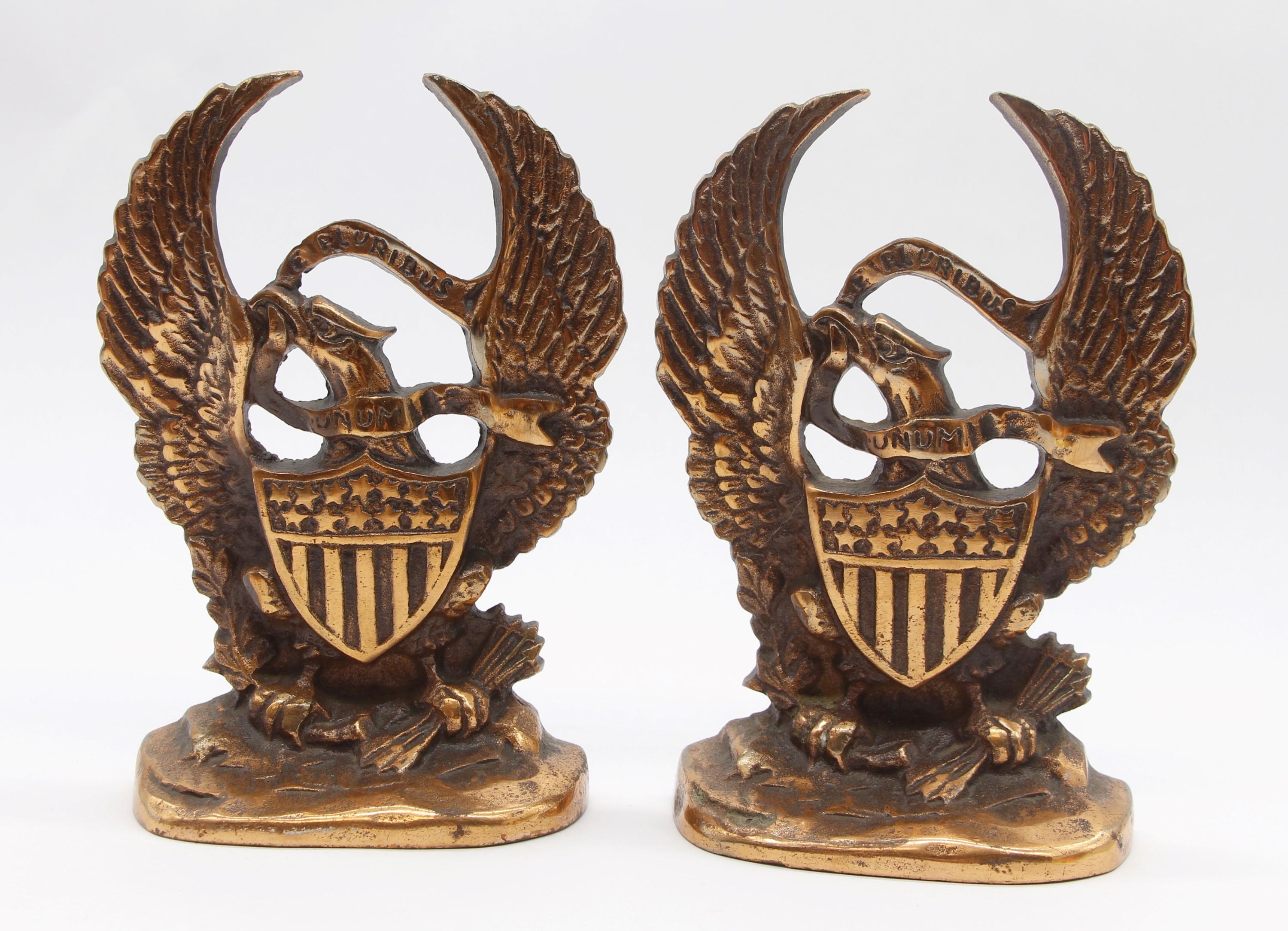 Stately early 20th Century pair of US eagle bookends. Each eagle has outstretched wings and a shield in front embossed with E Pluribus Unum, meaning 