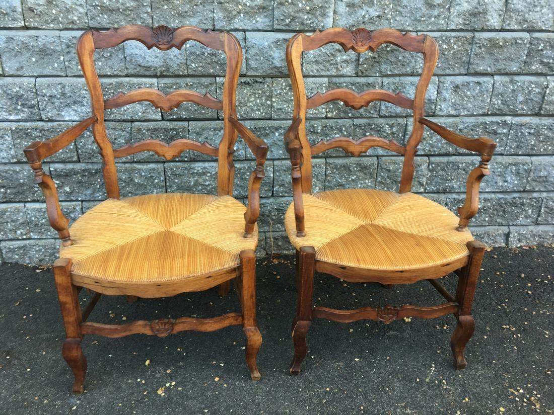 A pair of generously proportioned French country provincial style dining armchairs with carved shell accents on frame and rush seats. Wonderful as head dining chairs or office chairs.
Measures: Arm height 26.50
Seat height 15