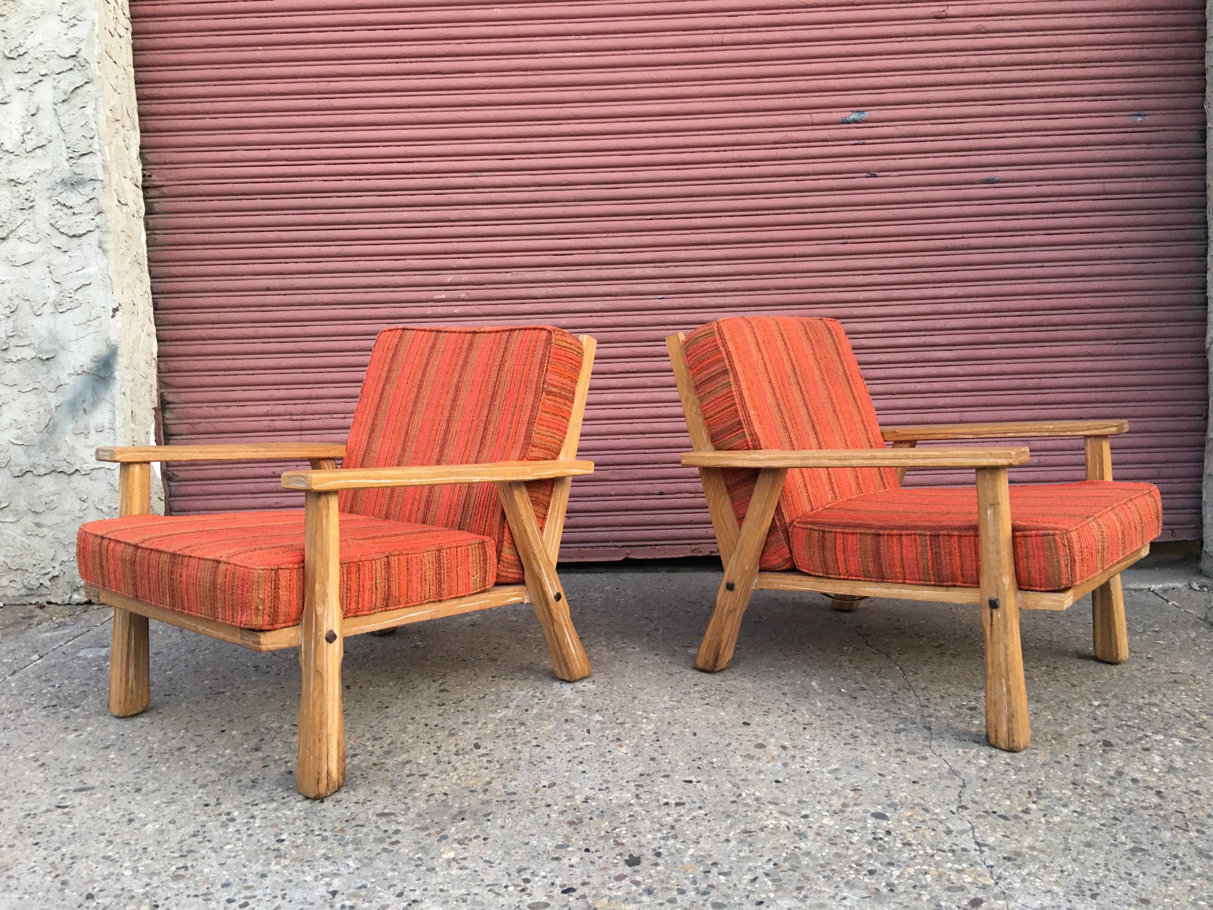 Pair of Cowboy modern pickled ranch oak lounge chairs. Chairs are dated 1962 and frames are solid oak with a light white pickled finish. Chairs have a striped fabric on them that is clean but needs some zipper work if you choose to use as is.