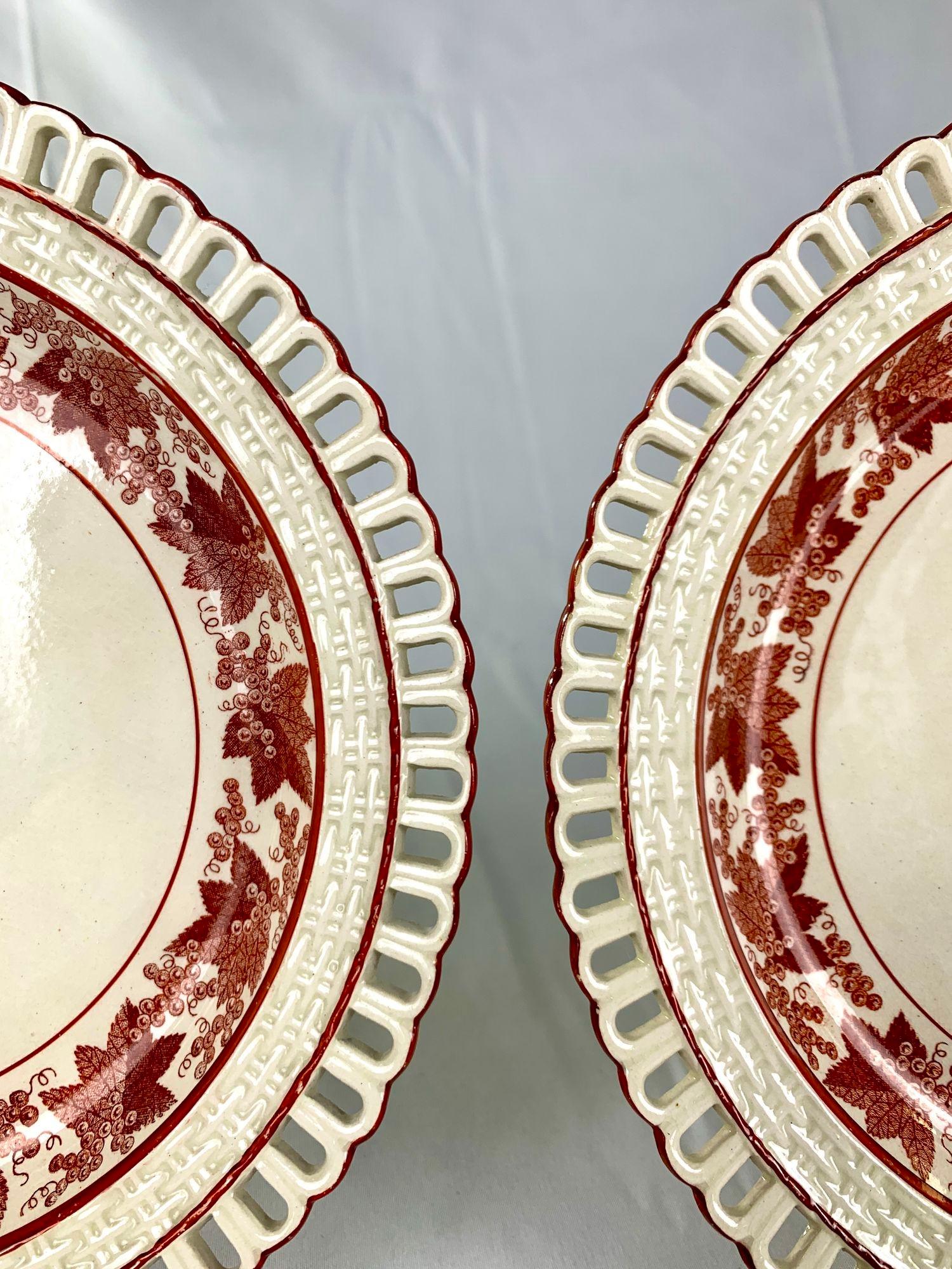 This pair of creamware dessert dishes dates to the early 19th century.
Made circa 1810, the dishes have beautiful decoration on their wide borders.
The borders consist of three concentric bands, each of which is encircled by a thin red line.
The