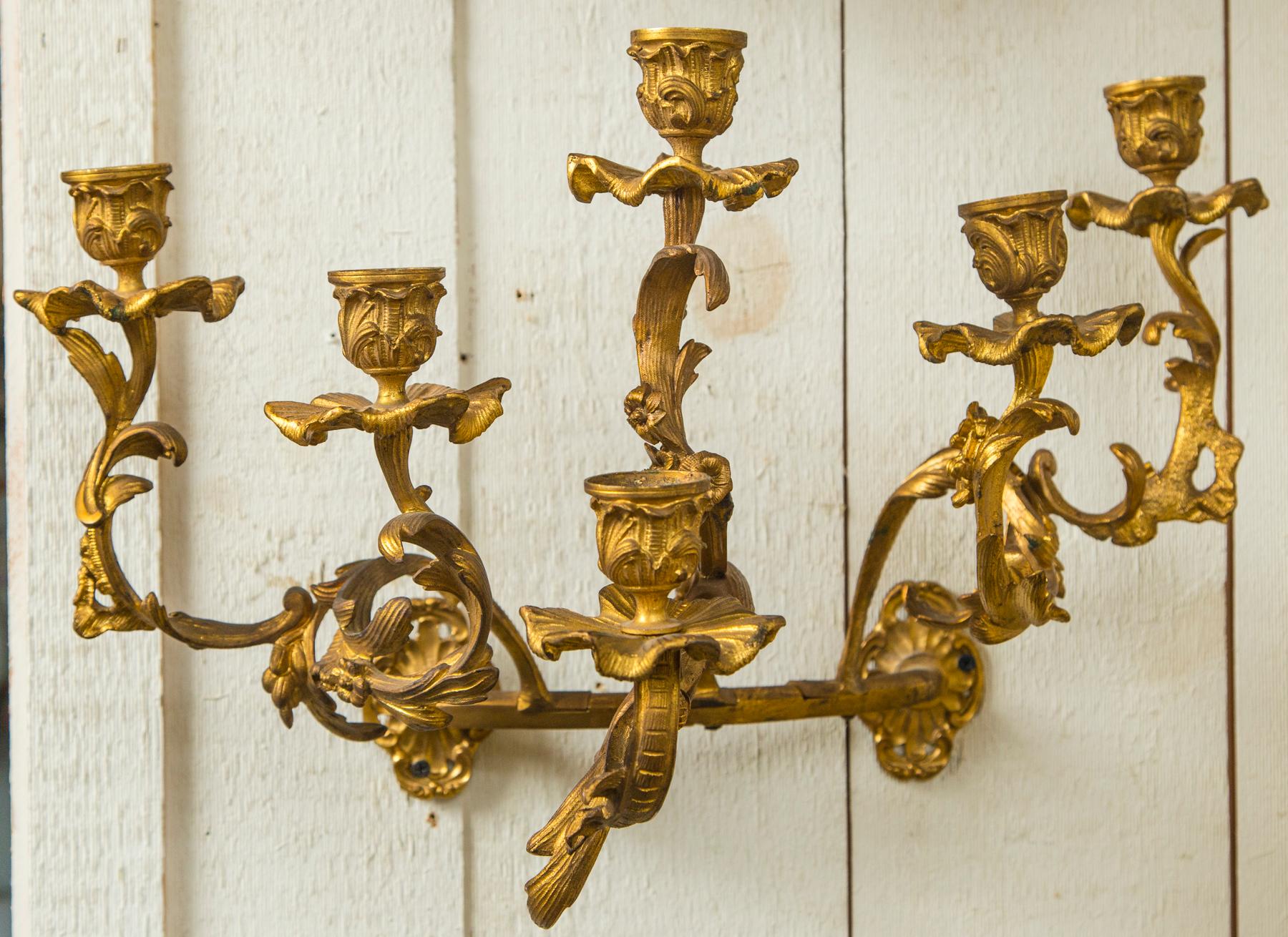 This pair of sconces are of an unusual half round or crescent form. Gilt bronze sconces, with graduated height arms and candle cups topped by single candle arm.
In the Rococo manner. 
Not electrified.