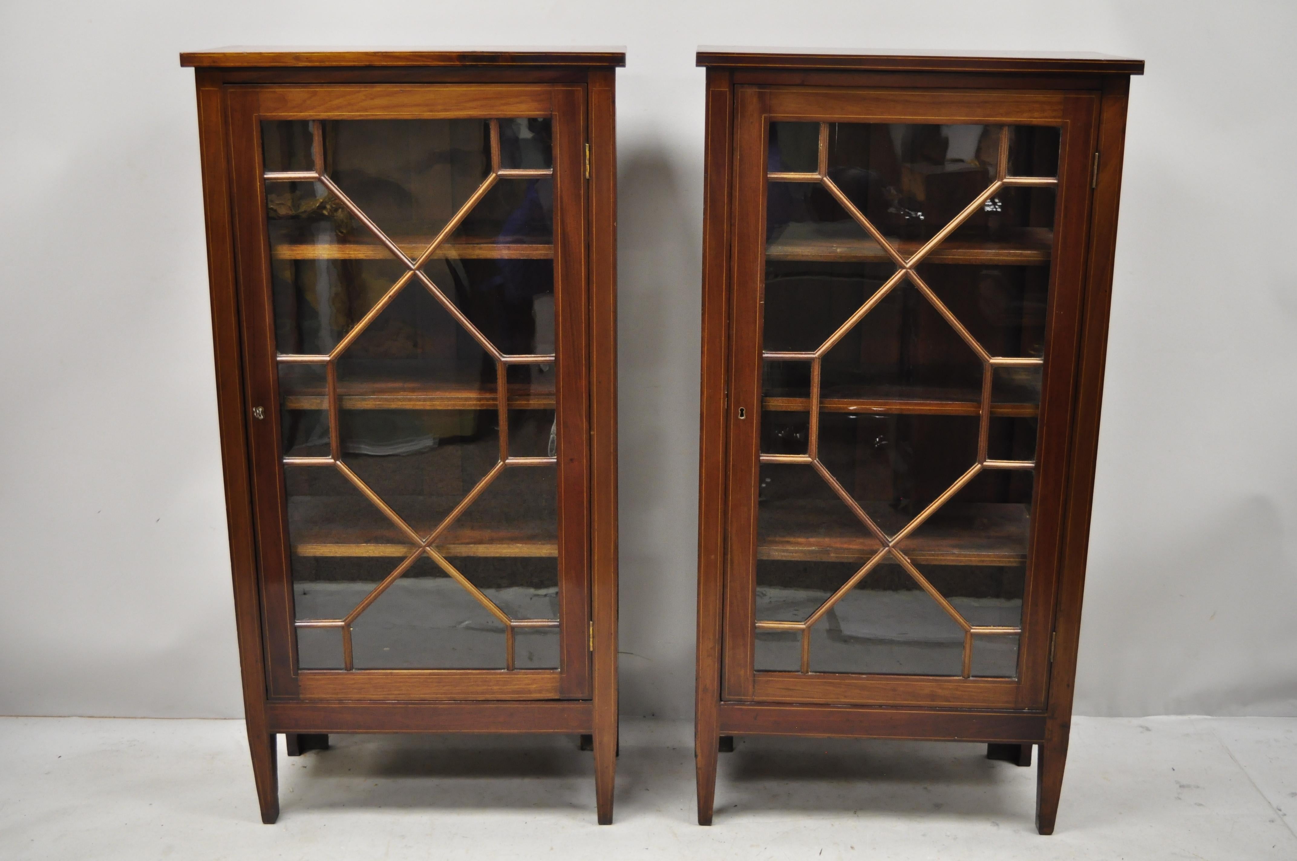 Pair of antique crotch mahogany inlaid Edwardian glass display cabinet curio bookcases. Listing features satinwood pencil inlay, individual panes of glass, glass sides, lattice doors, nice smaller size, solid wood construction, beautiful wood grain,