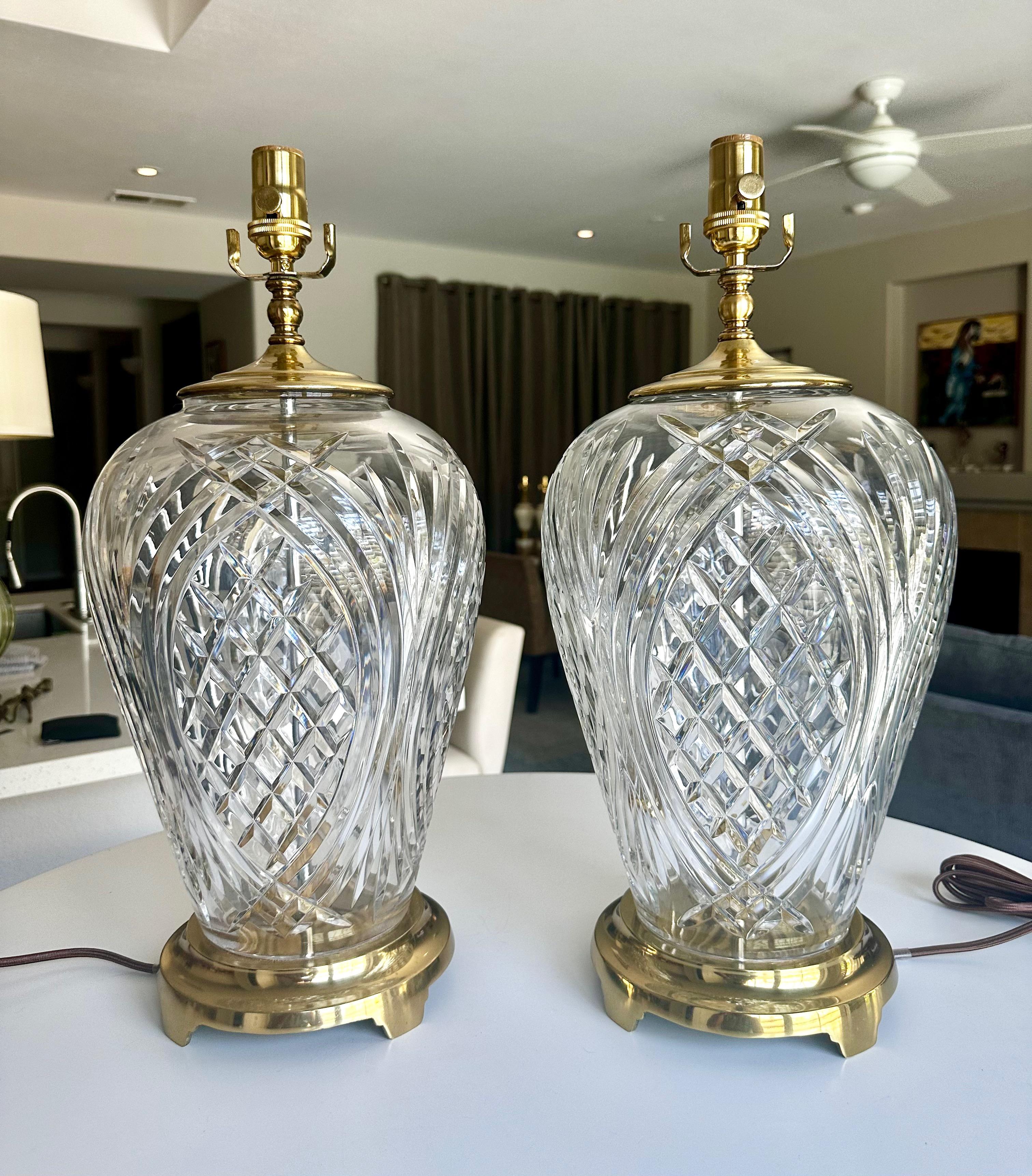 A pair of Waterford Crystal signed table lamps with with new 3 way socket and rayon cords. Each standing on brass bases with brass vase caps. Signed.