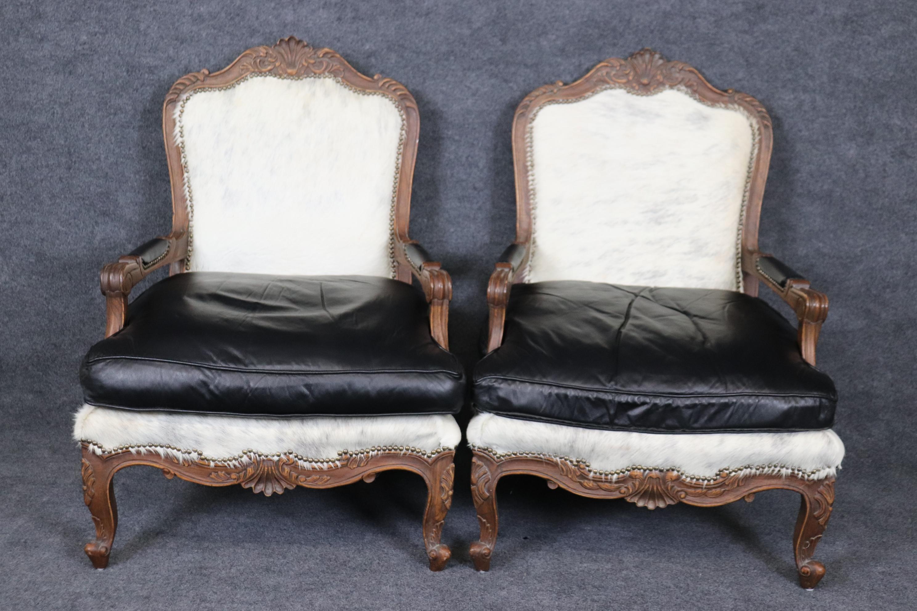 This is a superb and extremely expensive custom-made pair of 1940s era French Louis XV or Country French open arm bergere chairs. They are upholstered in natural cowhide and natural black leather. The chairs are in very good original condition and