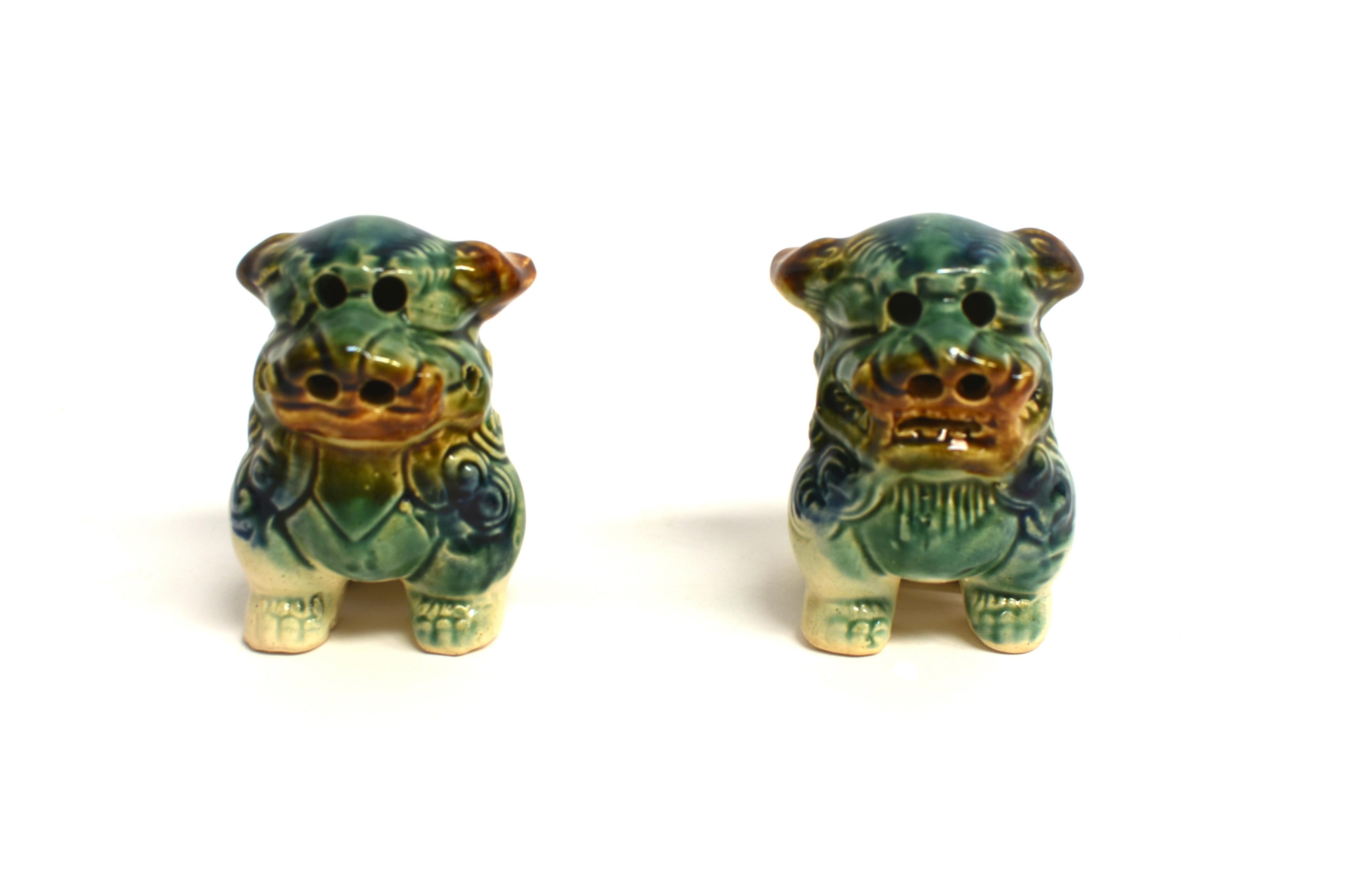 A pair of most adorable ceramic foo dog puppies. The large heads covered in curly hair with open mouths in a grin and perky ears. Short stubby legs and upright tails. The tri-glaze comprise caramel, blue and green color, hand applied to the puppies.