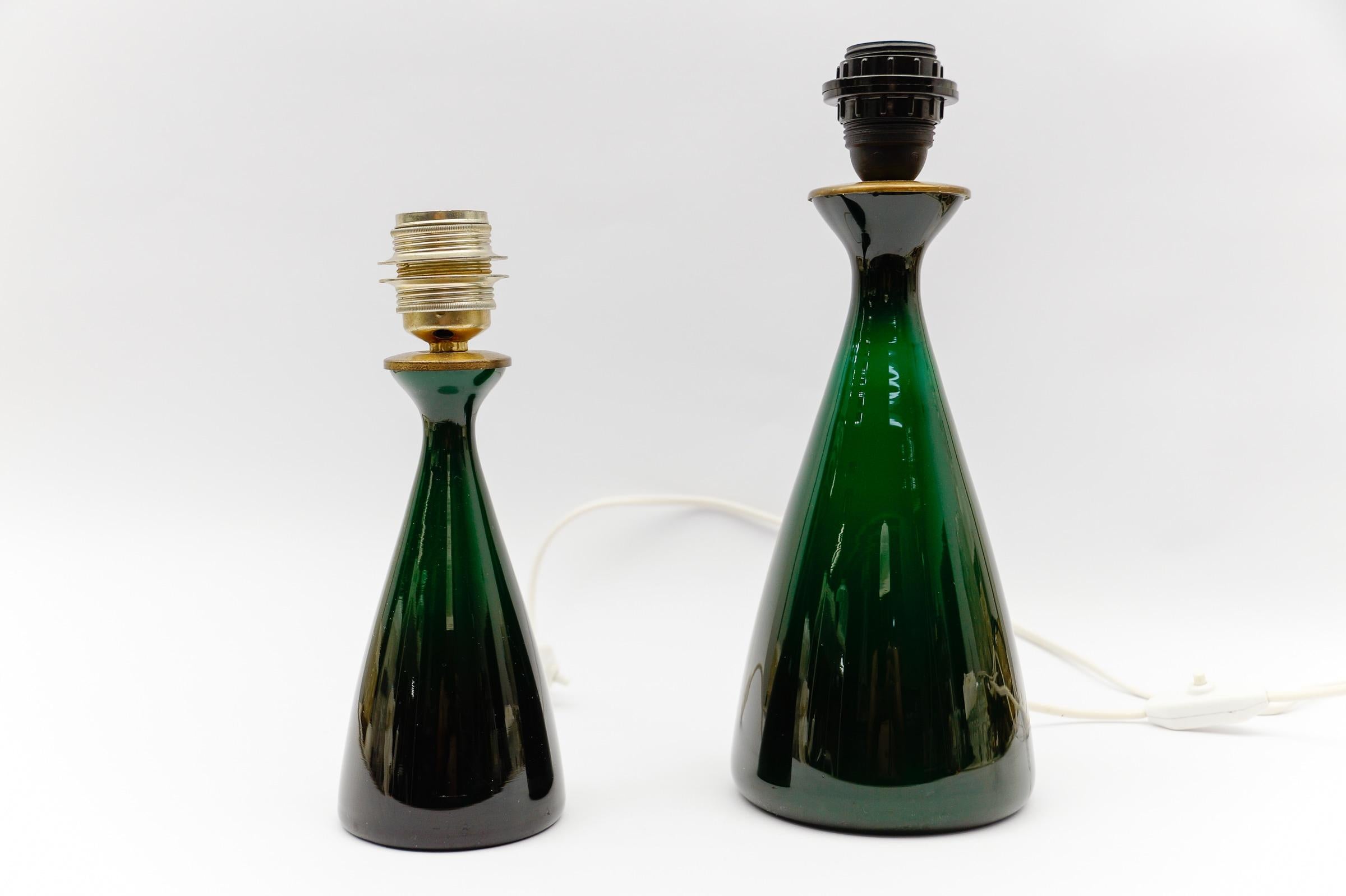 Paire de lampes de table en verre vert de Kastrup Holmegaard, 1960s

Deux hauteurs différentes 26cm et 33cm et deux diamètres différents 9,5cm et 13,5cm.

Les lampes sont équipées d'ampoules à vis E27 Edison. Il est en état de marche. Il fonctionne