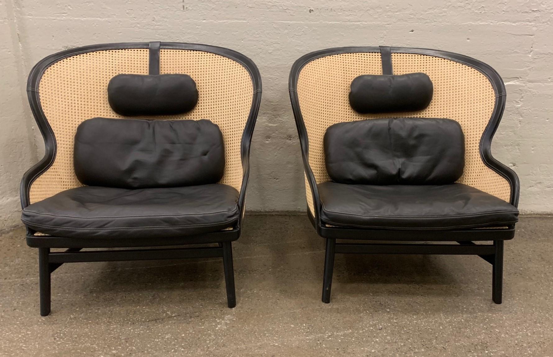 Pair of Danish leather and cane lounge chairs by Pierre Sindre for Garsnas. The chairs have curved backs and the legs are oak and black lacquered. The frame of the chairs is doubled caned and trimmed in leather of Tarnsjo as well as the cushions.