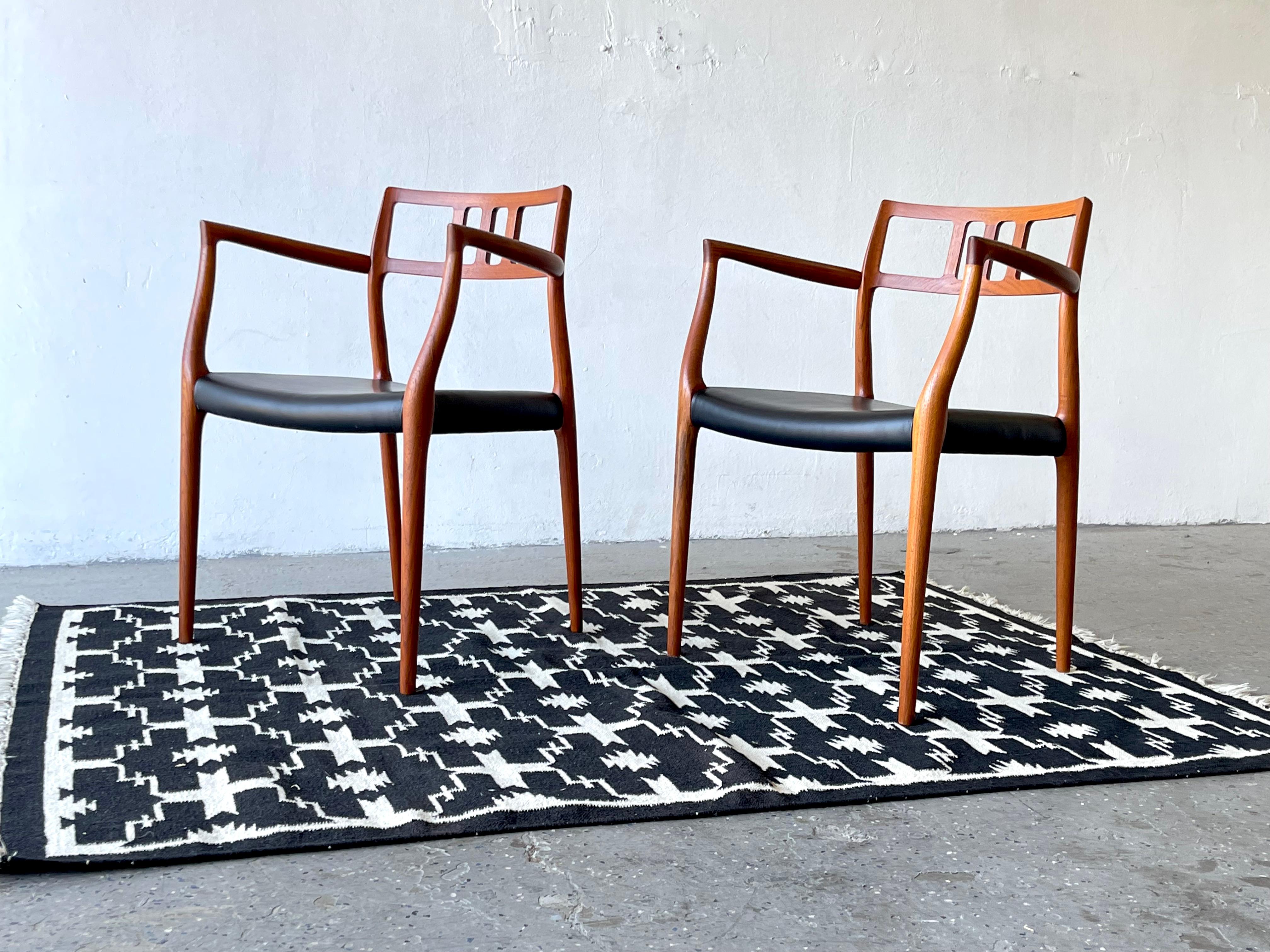 Pair of Model 64 Teak Armchairs By Niels Otto Møller 

A rarely seen pair of armchairs produced by J.L. Moller Mobelfabrik, Denmark and designed in 1966 by Niels Otto  Møller. Made from solid teak.  

The seats have been Reupholstered in high end