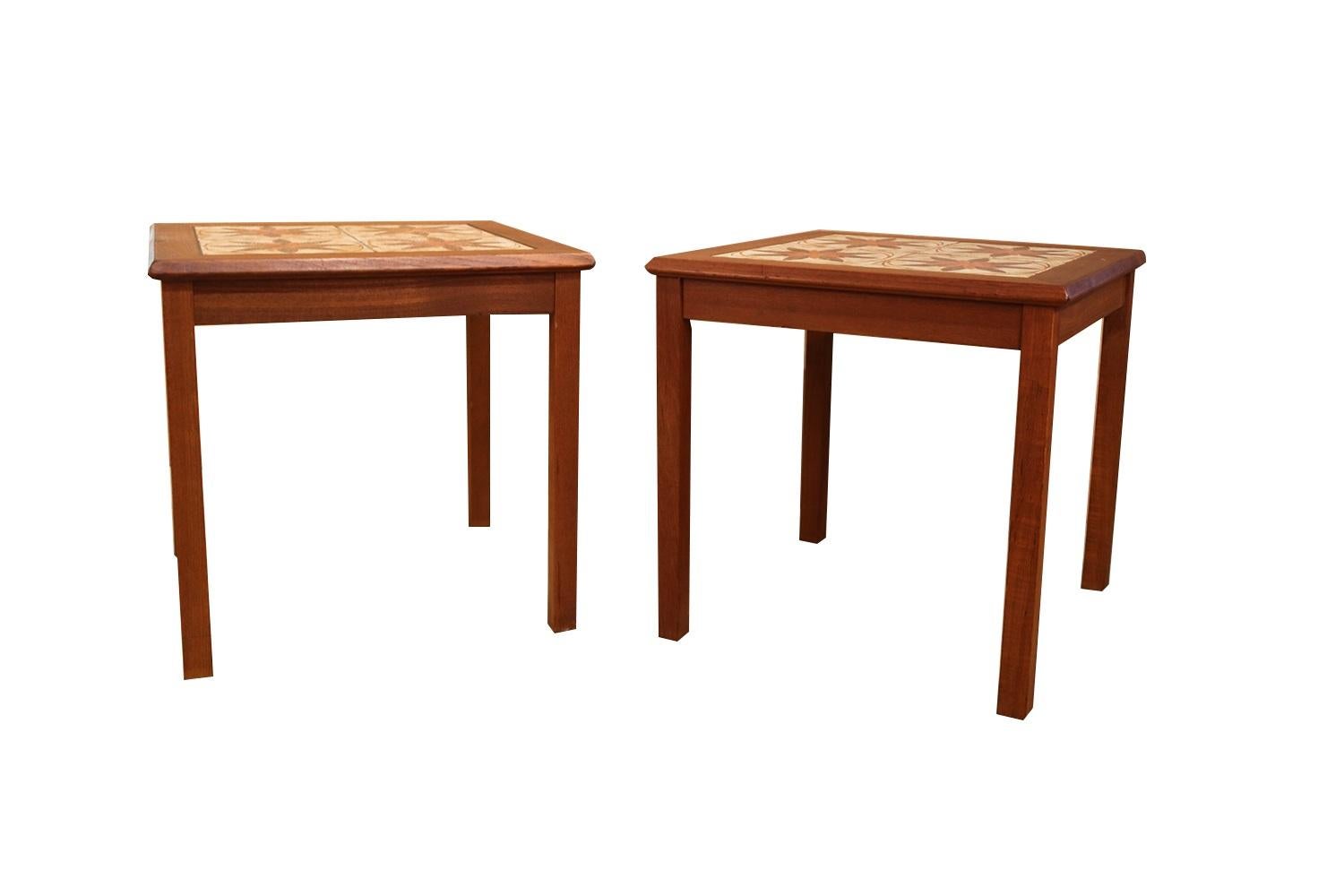 A beautiful set of Danish modern teak tile top square side/end tables attributed to Mobelfabrikken Toften of Denmark during the 1960s. The tabletop features 4 matching ceramic tiles framed in teak over four square solid teak legs. The tiles are