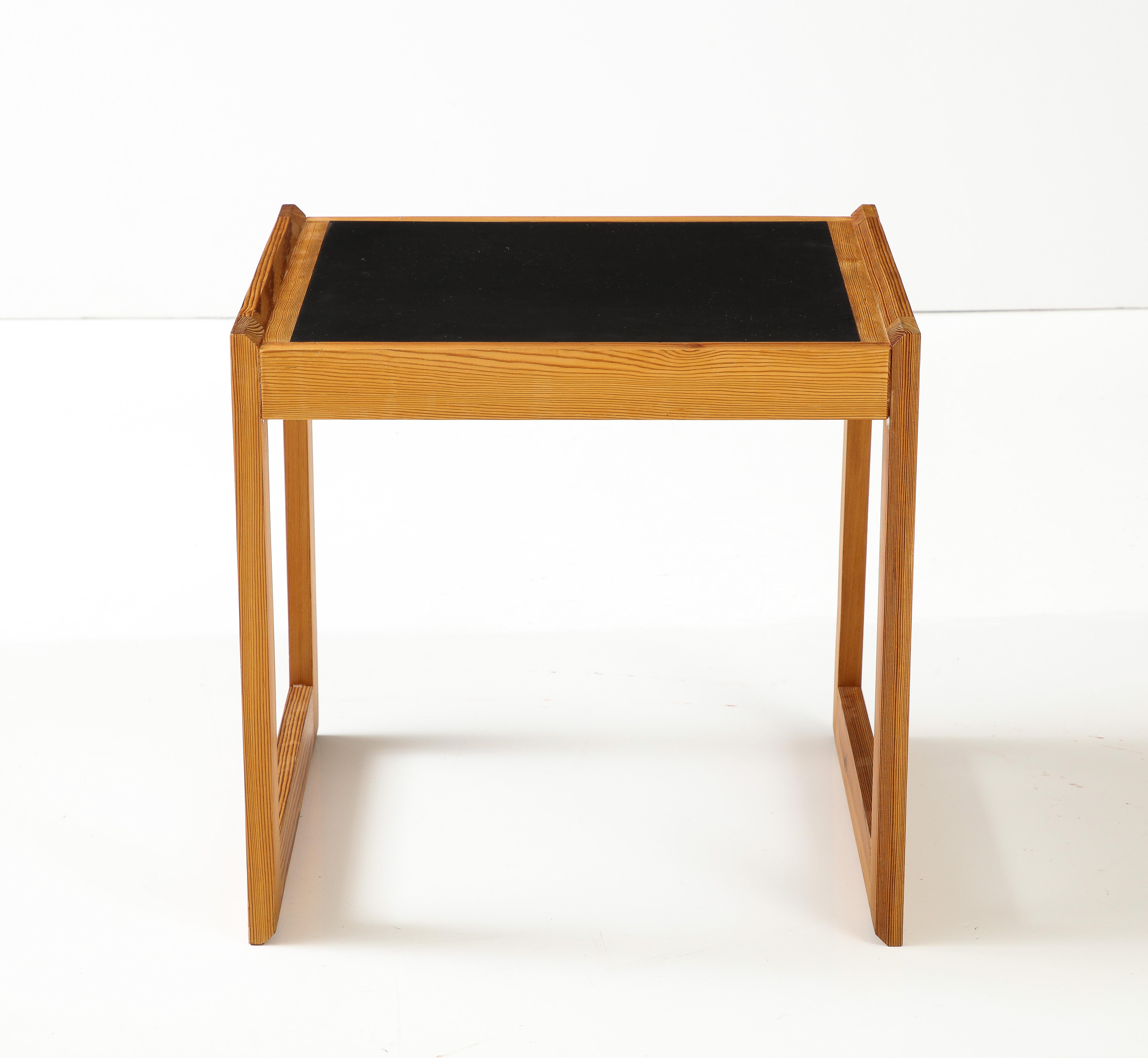 A pair of Danish pine and laminate side tables, attributed to Bernt Petersen, circa 1960s, the black laminate tops with a pine raised edge raised on a box form support. Old nicks in tops but overall a good feel. The pine has a great mellow patina.