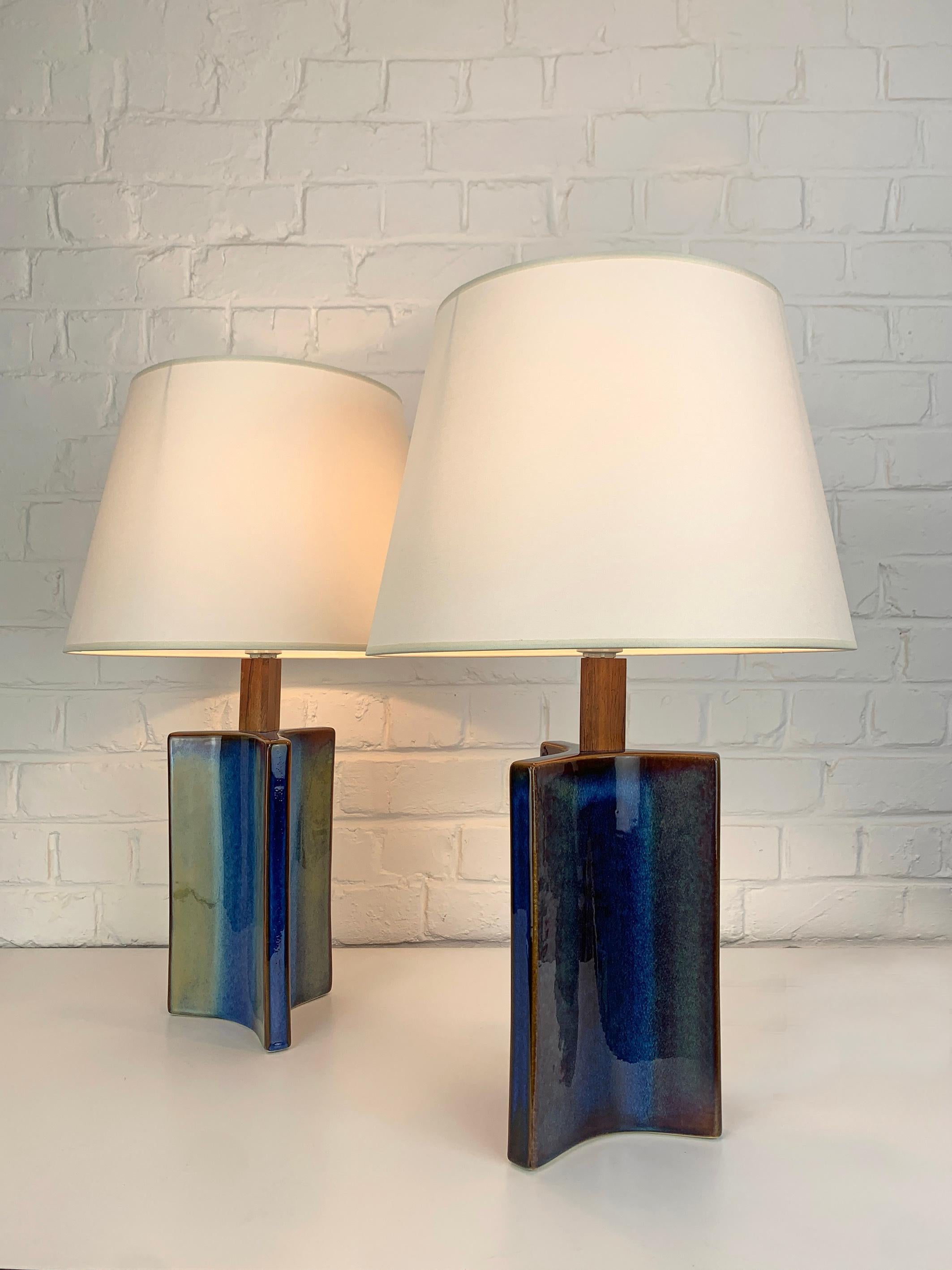 Ein Paar dänische Steingut-Tischlampen aus der Mitte des Jahrhunderts (1960-70). Glasiertes Steingut und Teakholz.

Skulpturale dreieckige Lampenfüße, blaue Glasur mit grün/braunen Farbeffekten. Sehr ungewöhnliche Form!

Hergestellt von Søholm
