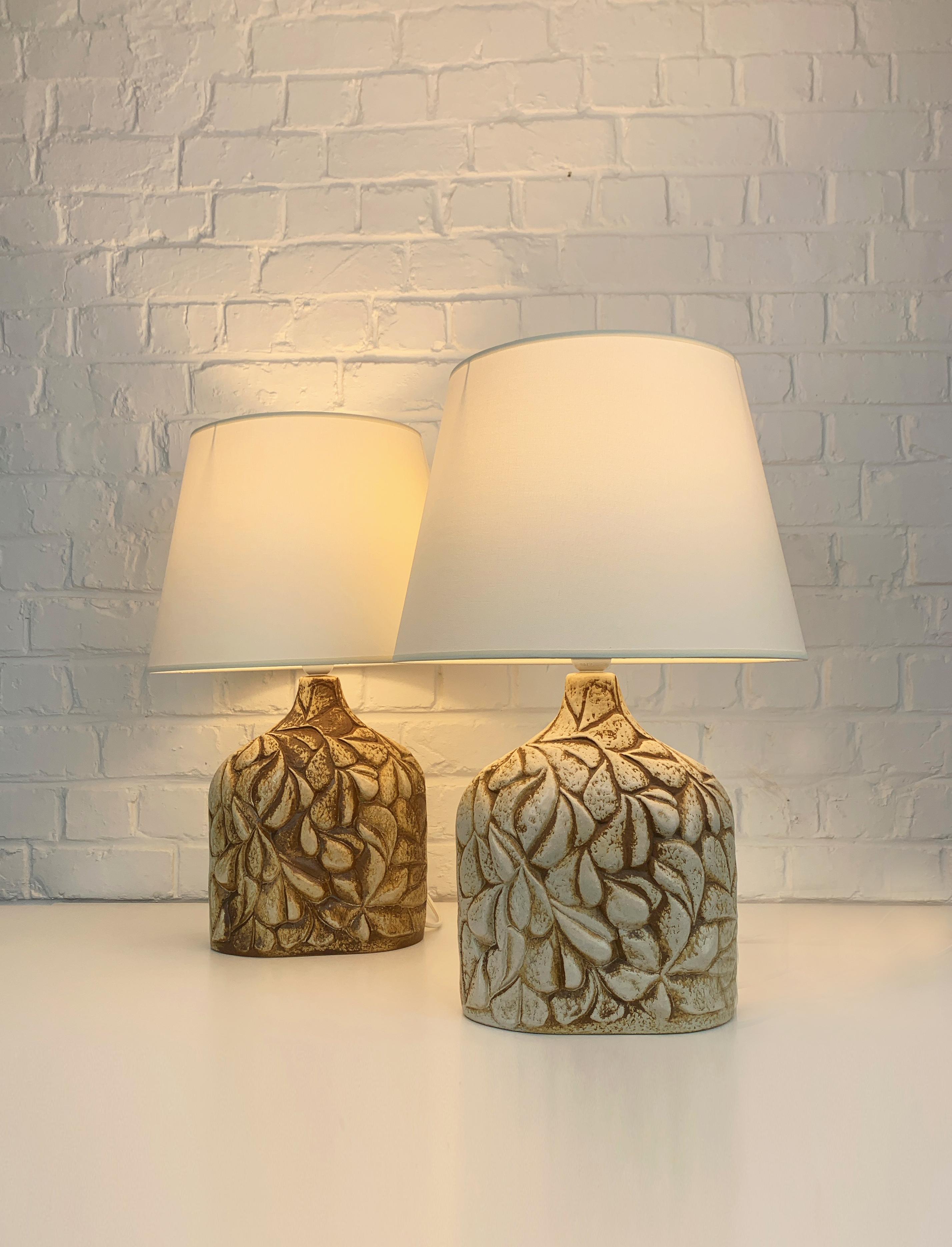 Pair of Danish Mid-Century stoneware table lamps of the 1970s, design by Haico Nitzsche. Sculptural lamp in earthy colored stoneware with impressed organic pattern of stylised leaves. 

Haico Nitzsche trained in ceramics in Germany before teaching