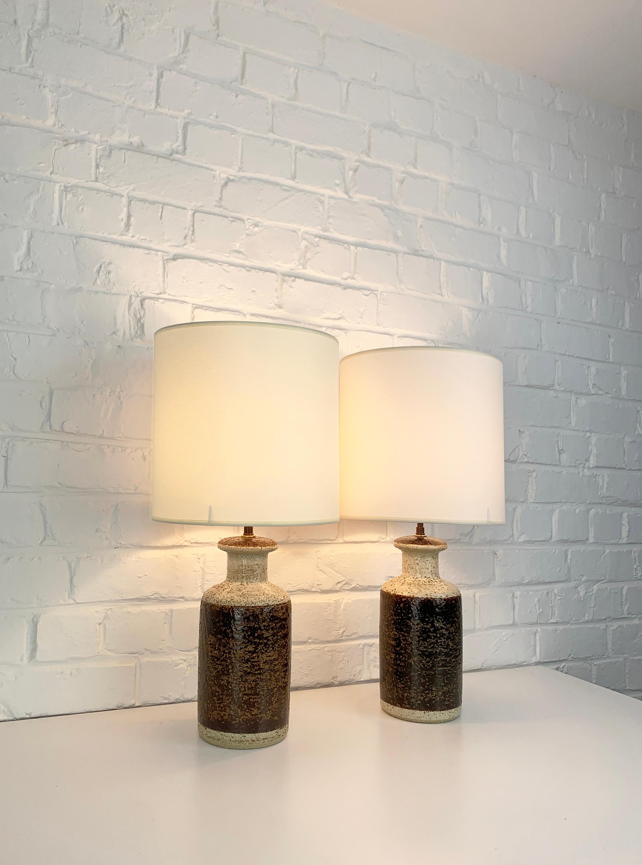 Pair of Danish Mid-Century stoneware table lamps of the 1970s, design by Svend Aage Jensen. 

Scuptural lamp bases made of chamotte clay with earth-tone glaze, chocolate brown and beige colors. These lamps exist in three different sizes, here the