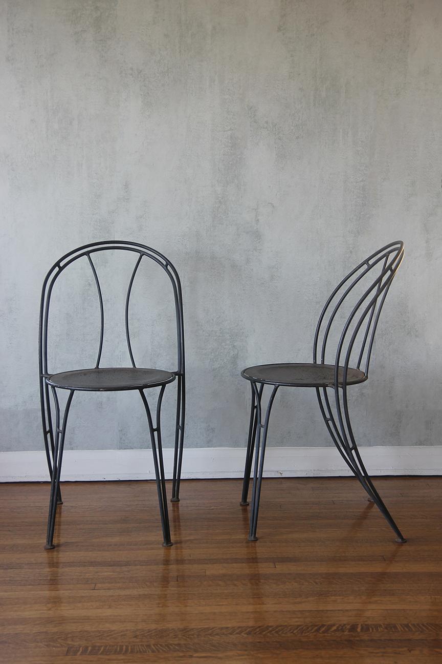 Einzigartiges Design: Verschönern Sie Ihren Raum mit einem auffälligen Paar eleganter dunkelblauer Metallstühle mit bogenförmigen Rückenlehnen. Diese modernen Stühle, die von einem robusten silbernen Metallgestell getragen werden, bieten sowohl