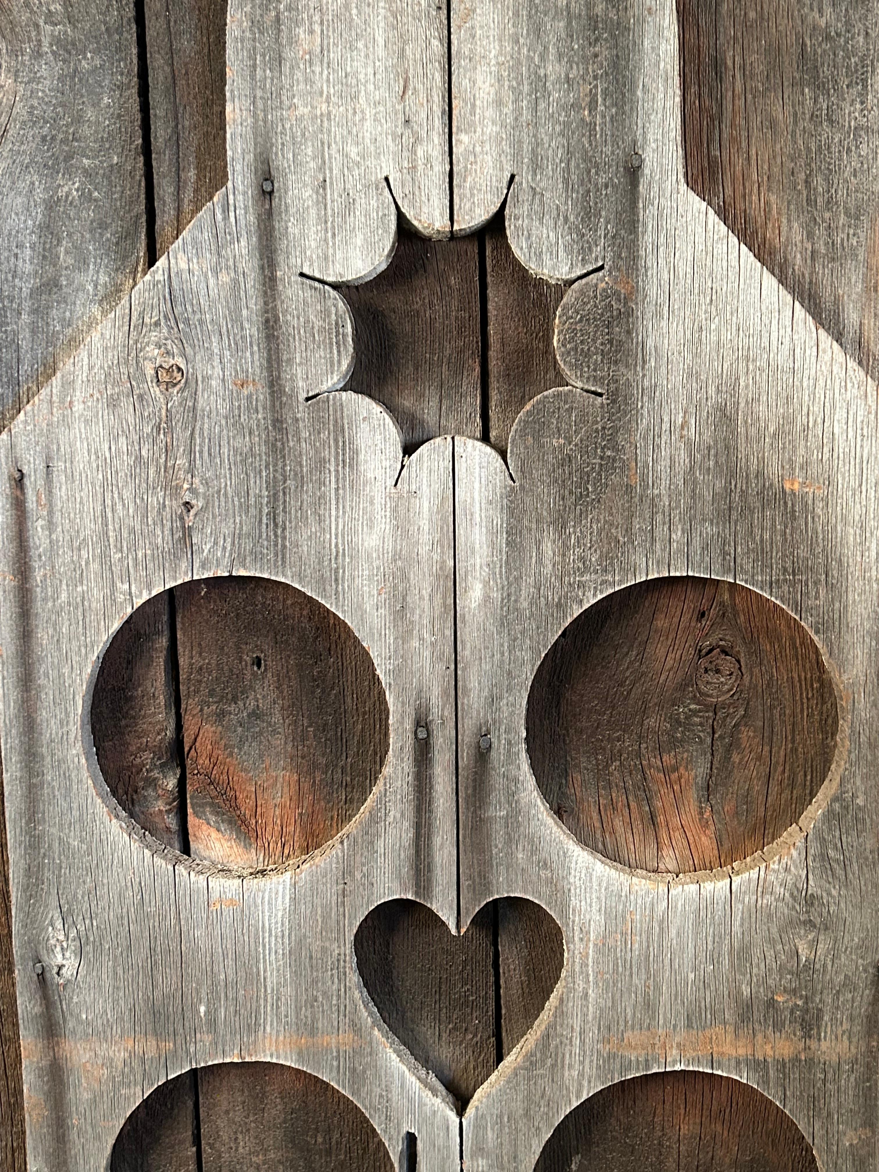 Meraviglioso elemento architettonico in forma di bottiglia applicata con cuori,  cerchio e disegno del sole. Il rivestimento grigio del fienile ha resistito alle intemperie per oltre 100 anni. In 2 sezioni da utilizzare come design a parete o come