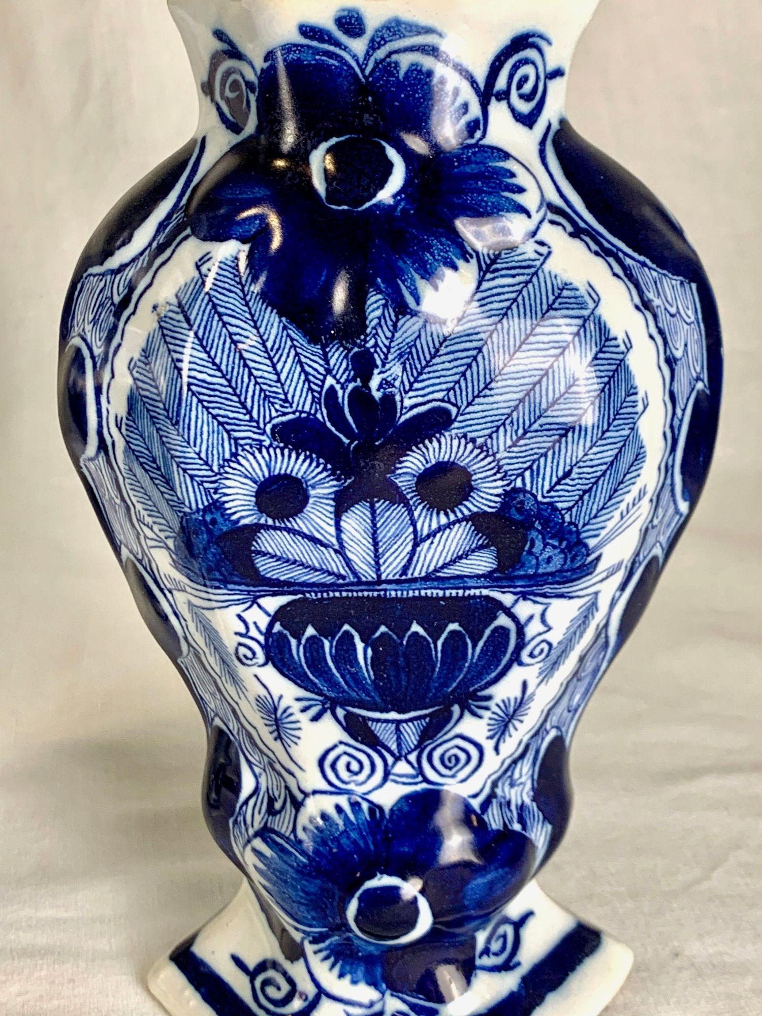 Cette paire de jarres anciennes à couvercle bleu et blanc de Delft, marquée pour The Claw** et datant d'environ 1820, est peinte à la main dans le style traditionnel de Delft.
Chaque pot est doté d'un couvercle surmonté du classique oiseau et de la