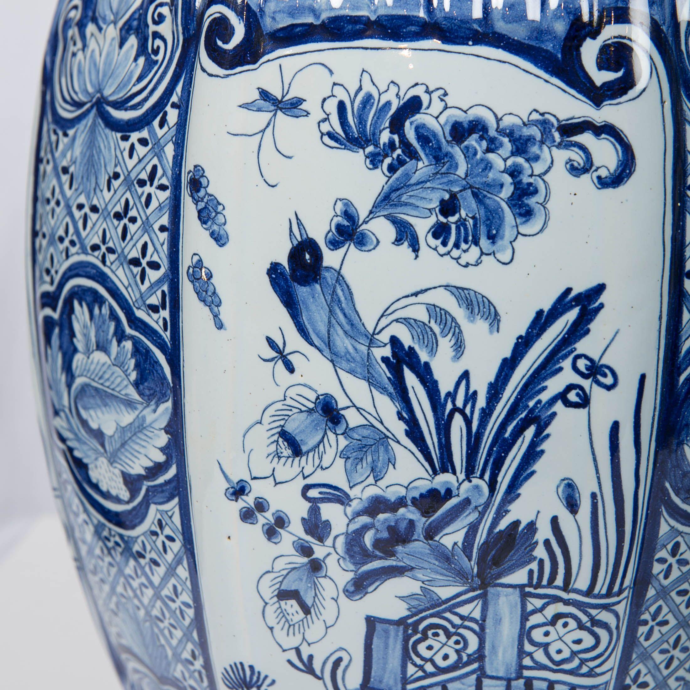 We are pleased to offer this large and beautiful pair of Dutch Delft Blue and White ginger jars. They are decorated with traditional Delft designs, and the jars are molded in a traditional Delft octagonal shape with a fluted surface. The fluting