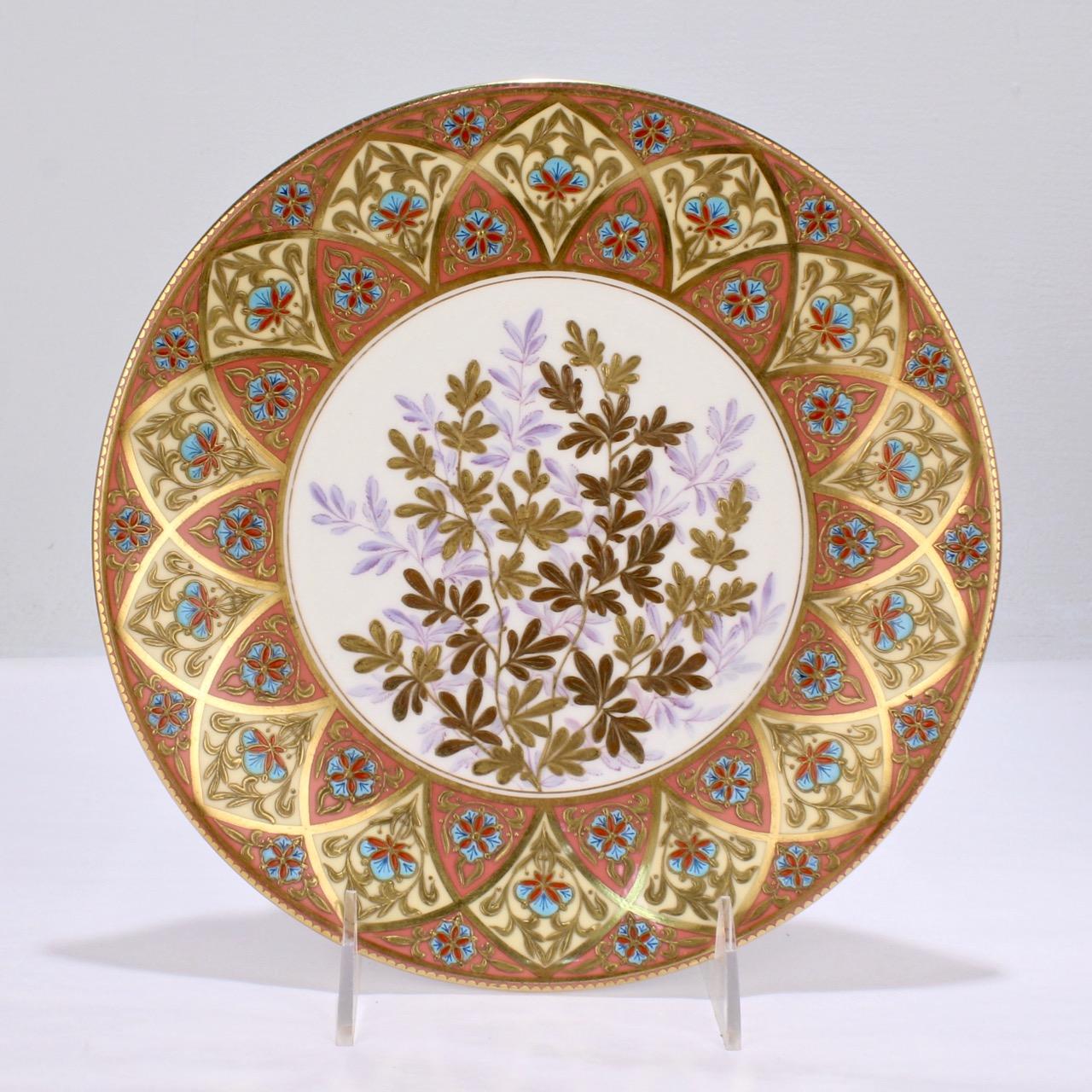 A very fine pari of antique Aesthetic period gilt and enameled cabinet plates by Derby porcelain (the predecessor to Royal Crown Derby).

The plates have a salmon and creme colored border with raised turquoise, red, and blue enamel highlights as