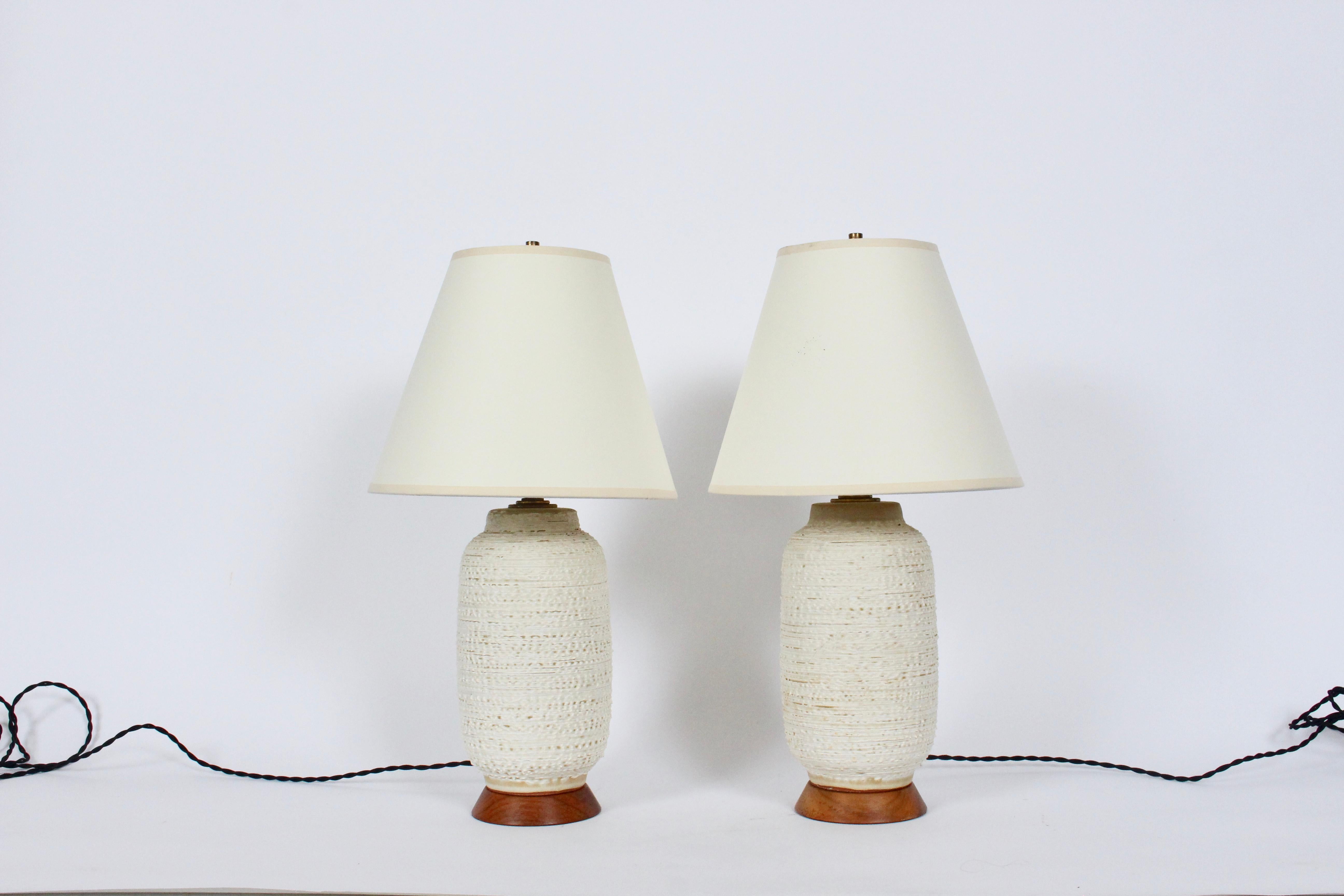 American Mid Century Modern Lee Rosen for Design Technics textured, glazed pottery bedside lamps. Featuring handcrafted petite and rare Design Technics forms with stipple glaze a top flared Walnut bases. 13H to top of sockets. 10H to top of Ceramic.