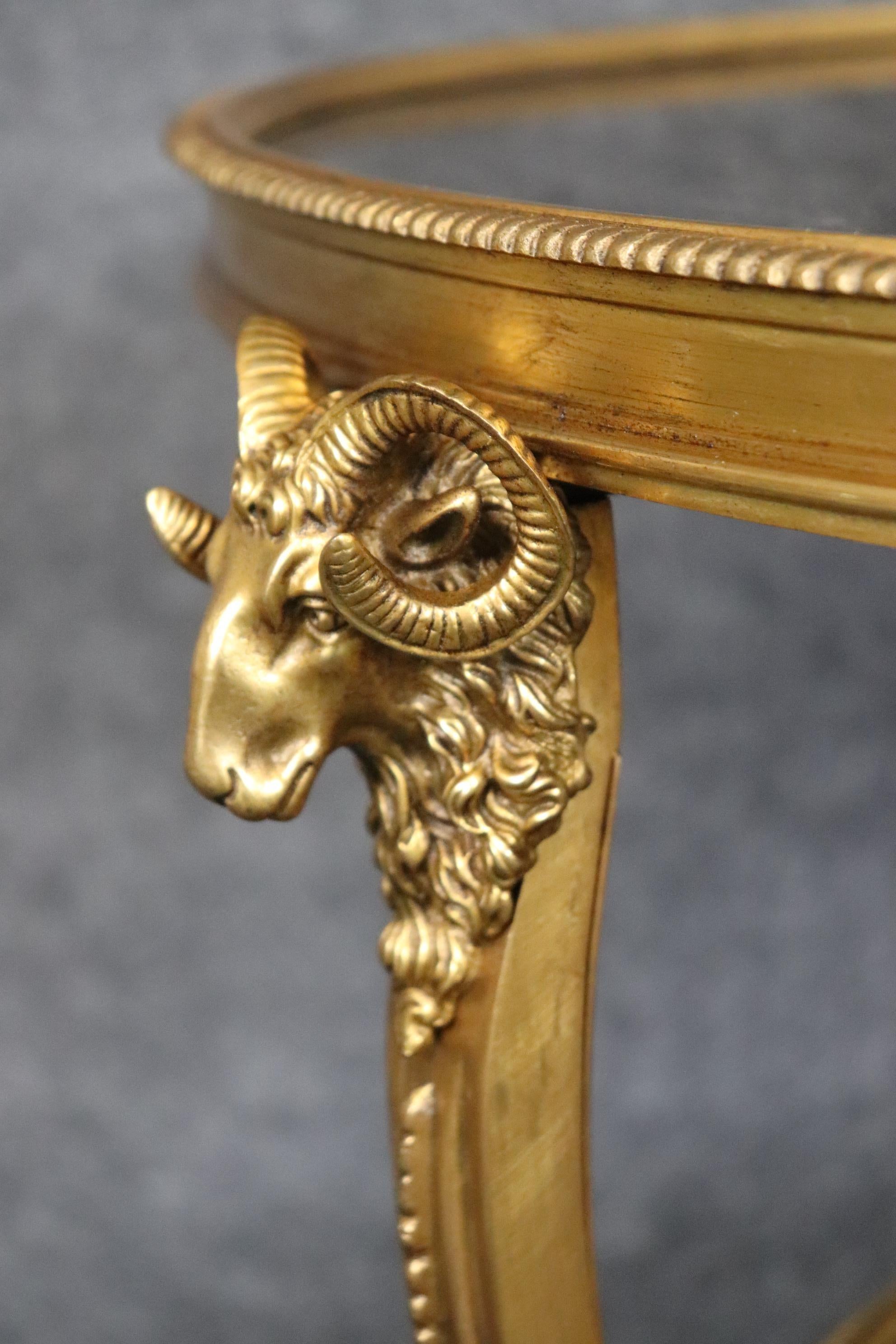 This is a superb pair of dore' gilt bronze gueridons with incredible workmanship and bright 23kt gold dore' finishing. The rams heads are superbly cast and highly naturalistic and well-defined. The table features gorgeous varigated black marble tops
