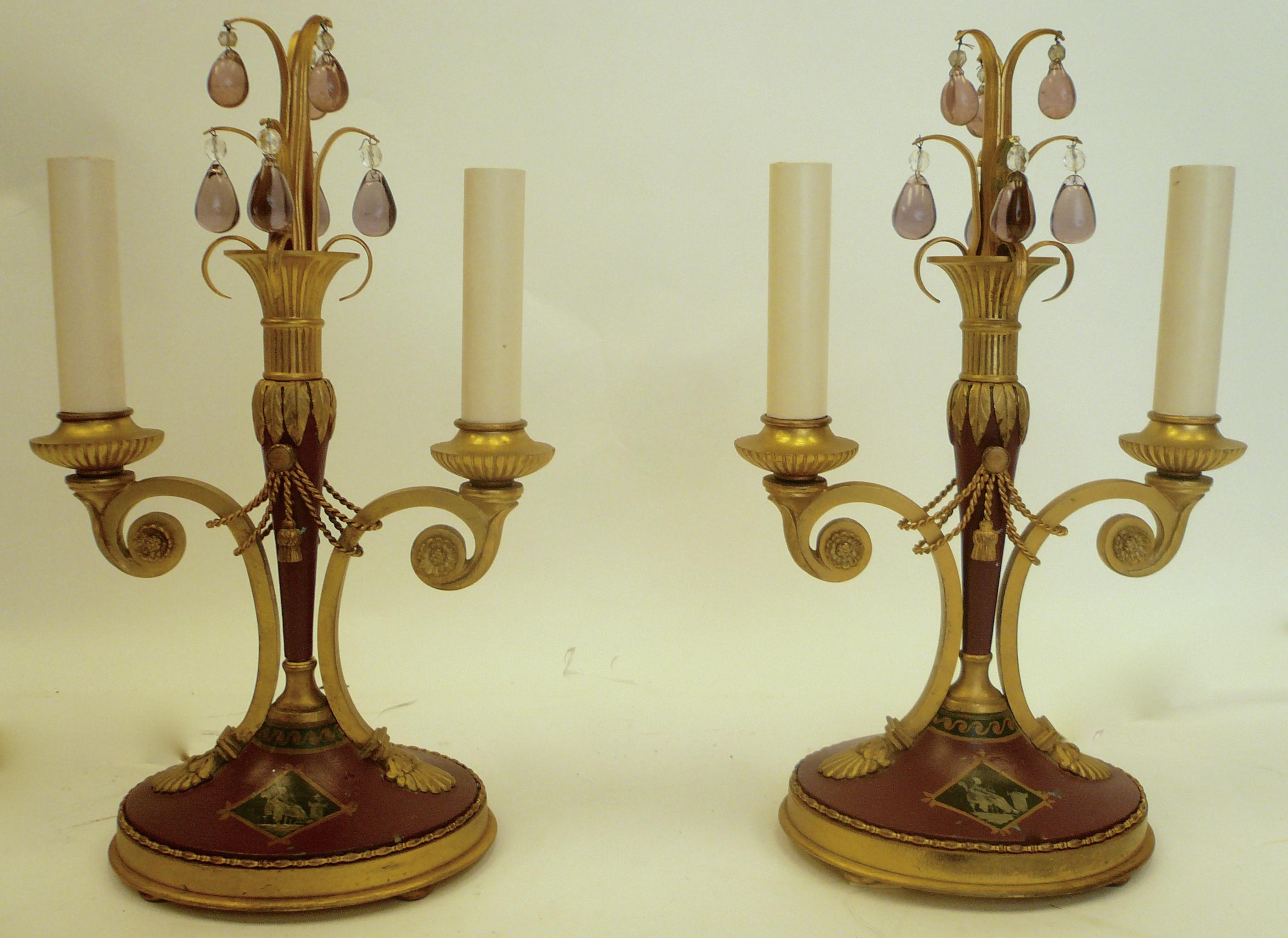 This handsome pair of lamps feature Classical motifs including swags, tassels, and acanthus leaves. The gilt bronze is accented by Wedgwood jasperware style hand painted designs, and trimmed with pale amethyst crystal drops.