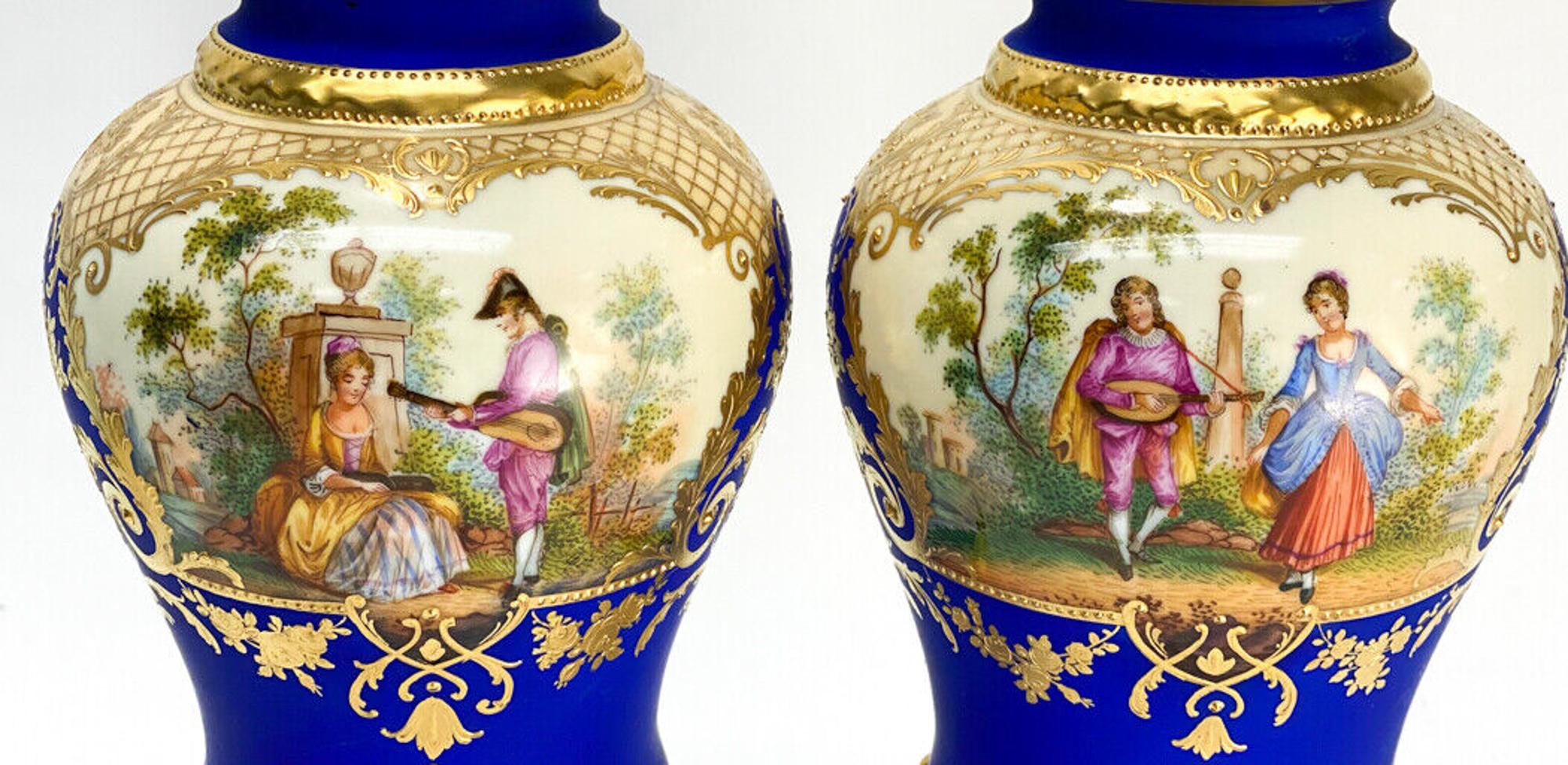 Pair Dresden Germany Porcelain Urns. A matte cobalt blue ground with hand painted courting scenes to the central area. Marked to underside.

Additional Information: 
Type: Urns
Weight Approx.,  2 lb
Measures Approx.,  4.75 inches diameter x 13.25