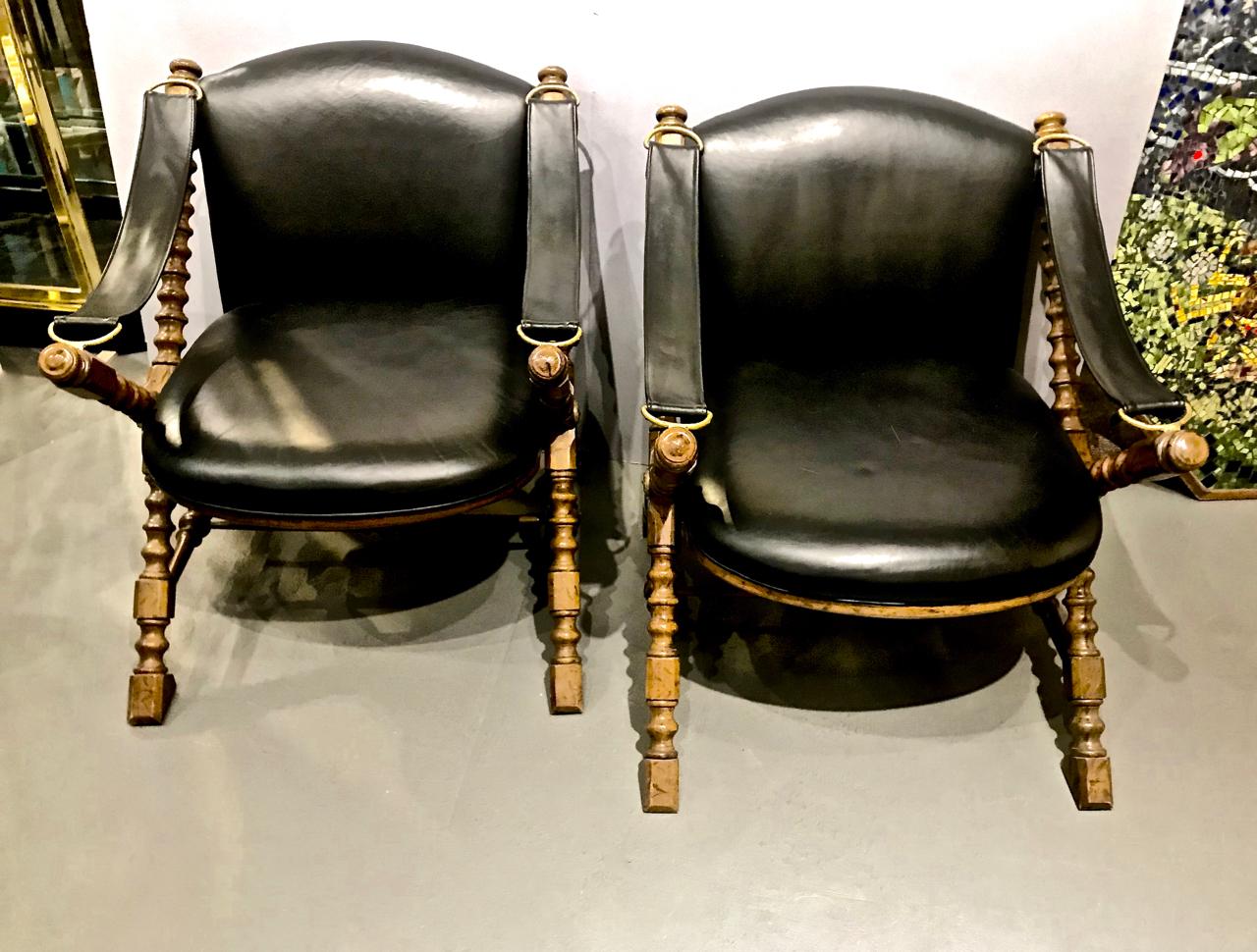 This is a superb pair of carved wood and leather campaign or safari chairs by Drexel that dates to the 1970s. Both chairs retain their original wood surface and leather upholstery which in very good condition. The leather armrest straps are