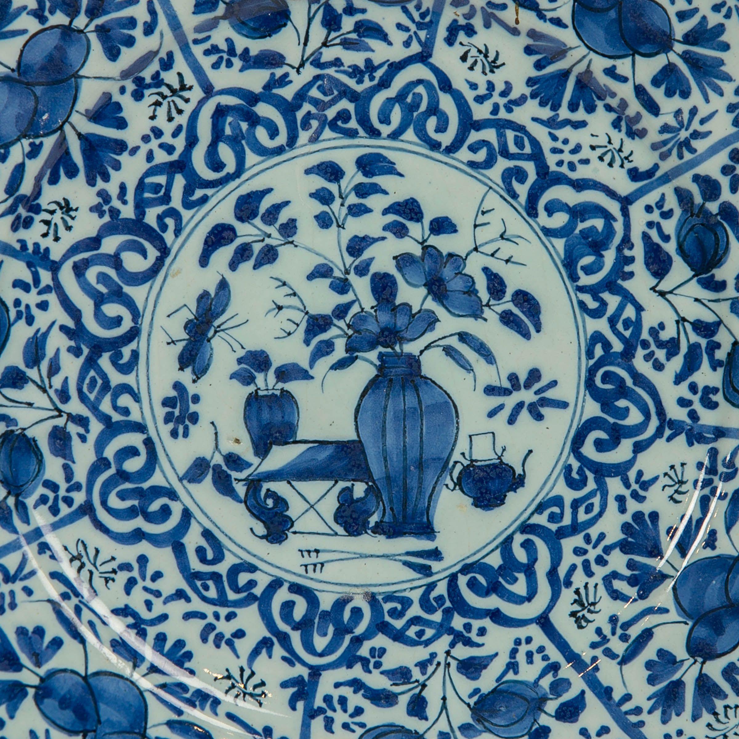 Provenance:
According to the paper label on the back of the plate this pair of dishes was part of the collection from *Heydon Hall, Norfolk England.
 Painted with cobalt blue, decorated in the center with a flower filled vase this pair of plates