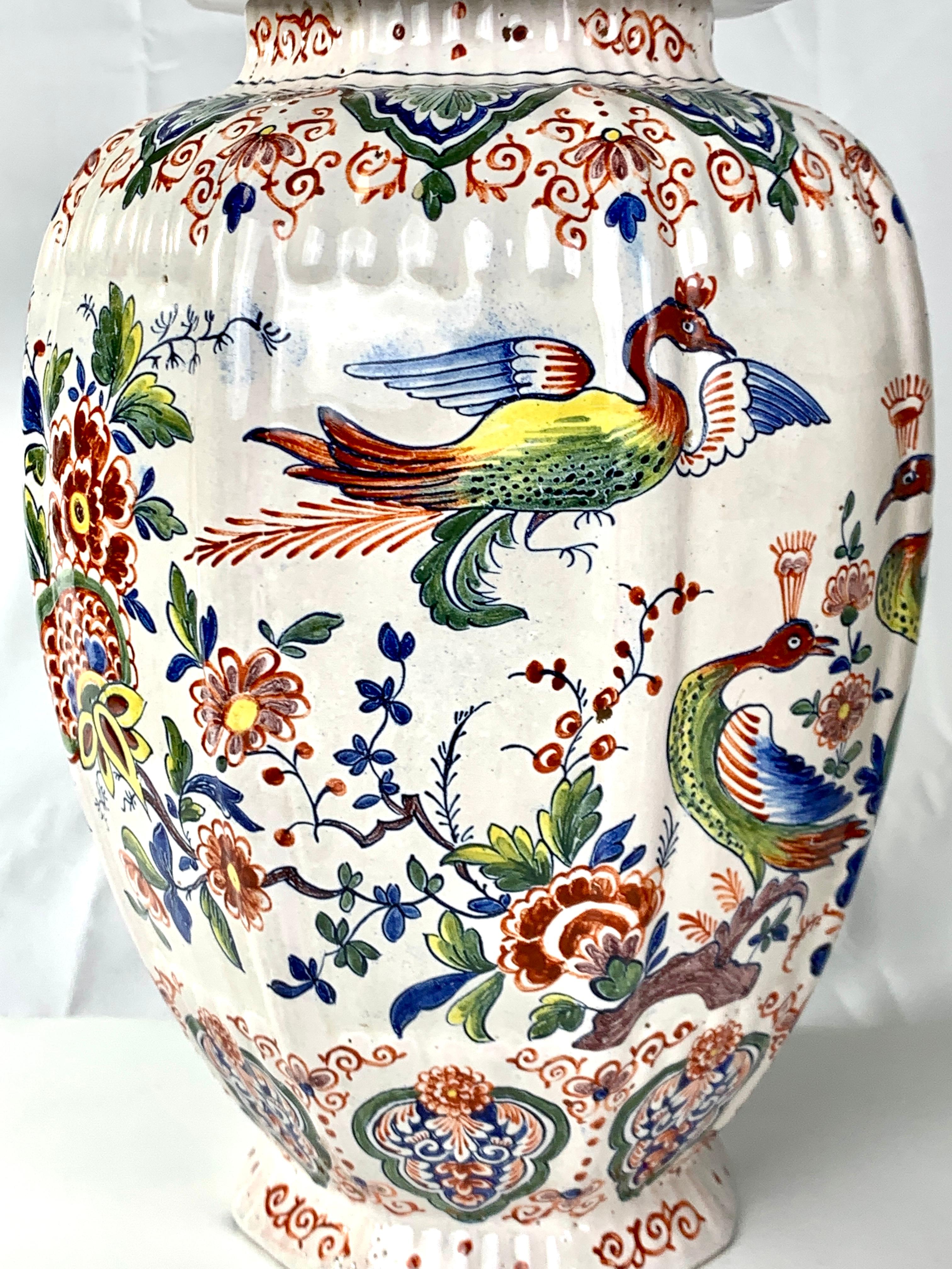 Looking at these jars, we see a lush garden with peacocks and stylized flowers in full bloom. There are five large peacocks!
This pair of Dutch Delft jars is hand-painted in the traditional Delft polychrome colors of iron red, manganese, moss green,