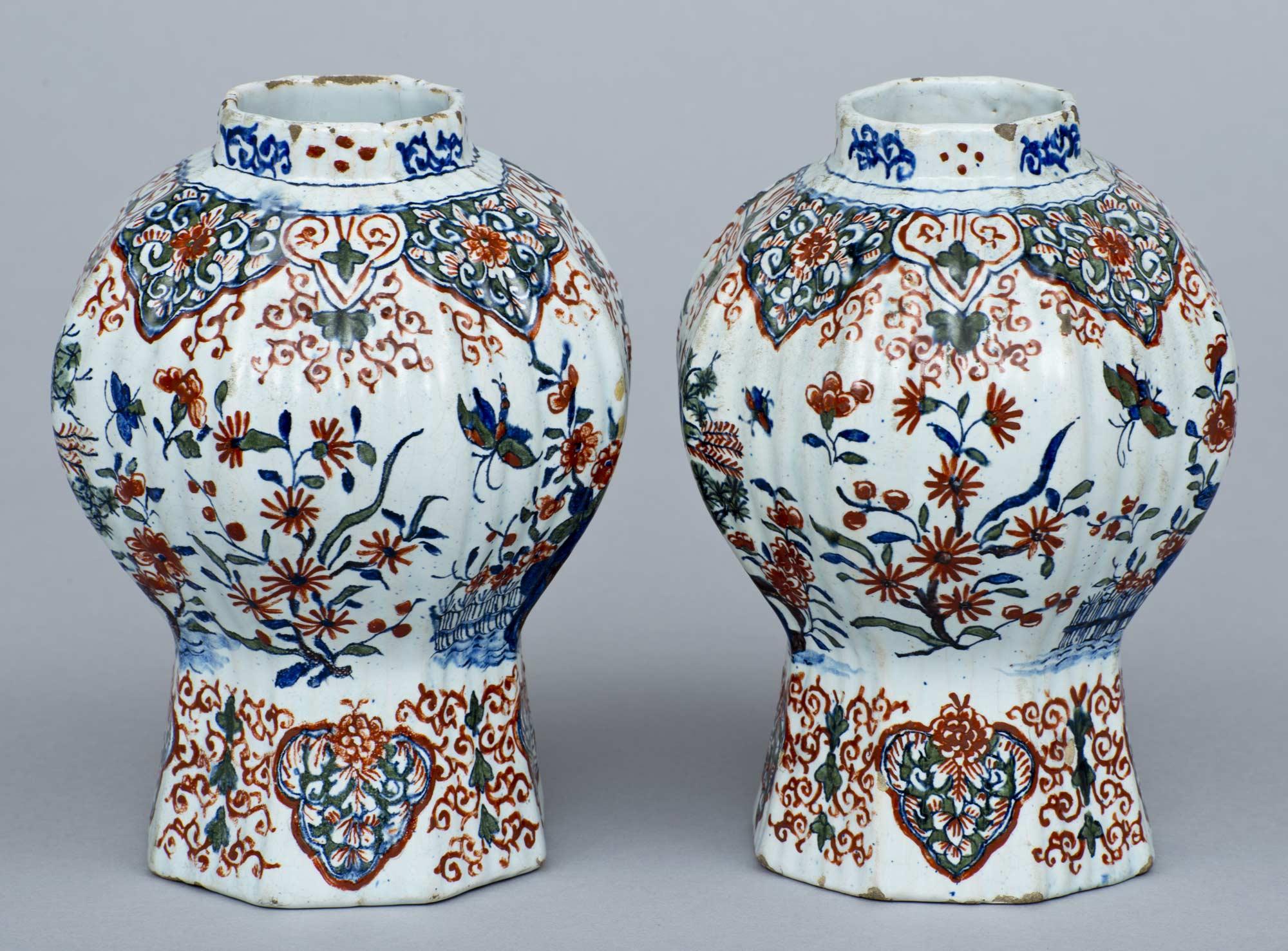 Pair of early delft octagonal and ribbed vases, polychrome decorated in iron red, blue and green with birds perched on branches, insects and flowers. The bottom painted in red “APK”: Adrian Pynacker.